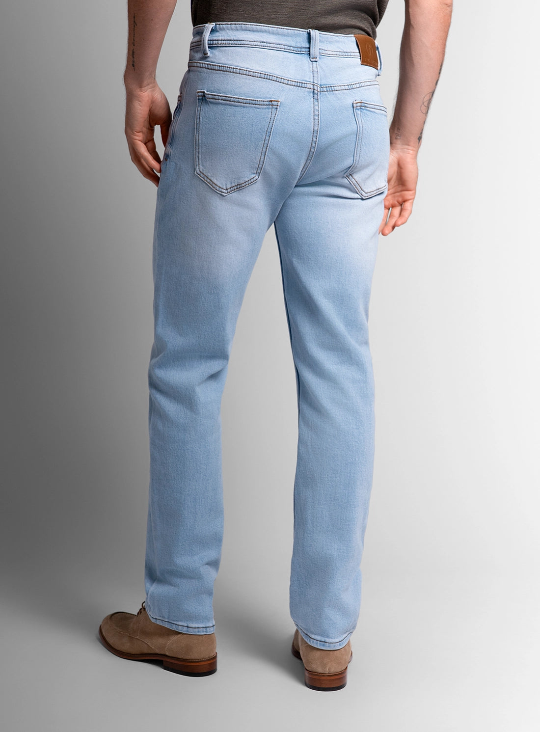 Light blue jeans worn by a person on a gray background