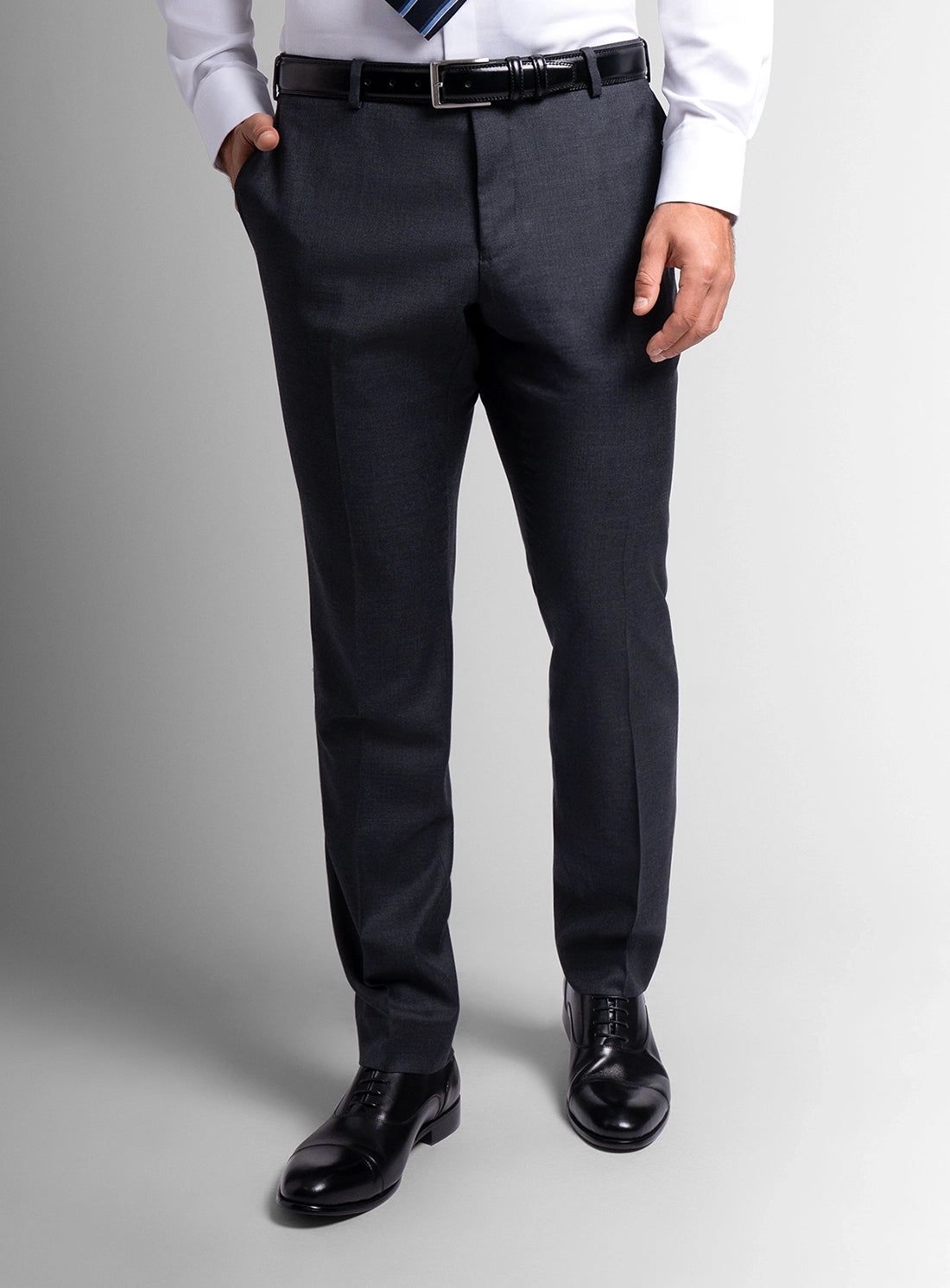 Person wearing a white shirt, black pants, and black shoes on a gray background