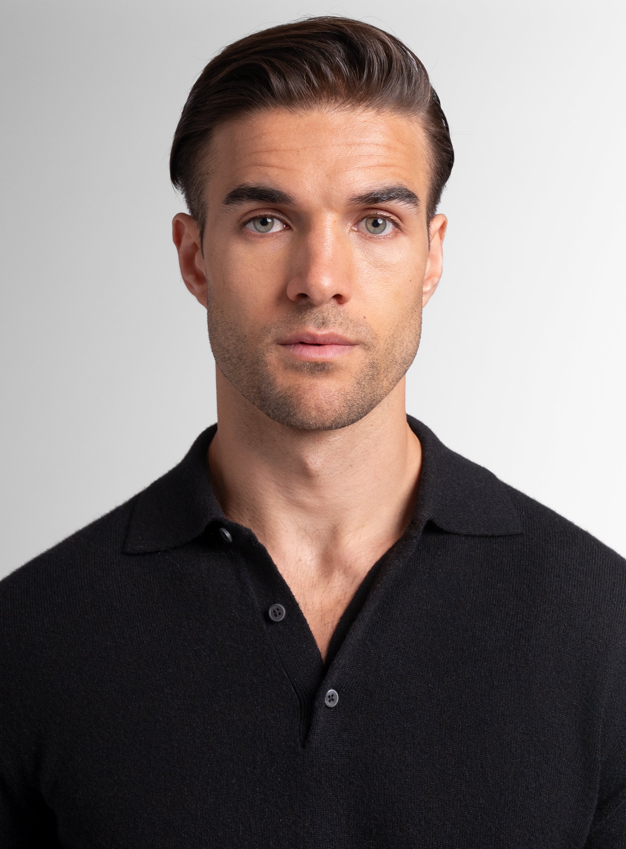 Close-up of a man wearing the Wool/Cashmere Long Sleeve Black Polo Knit
