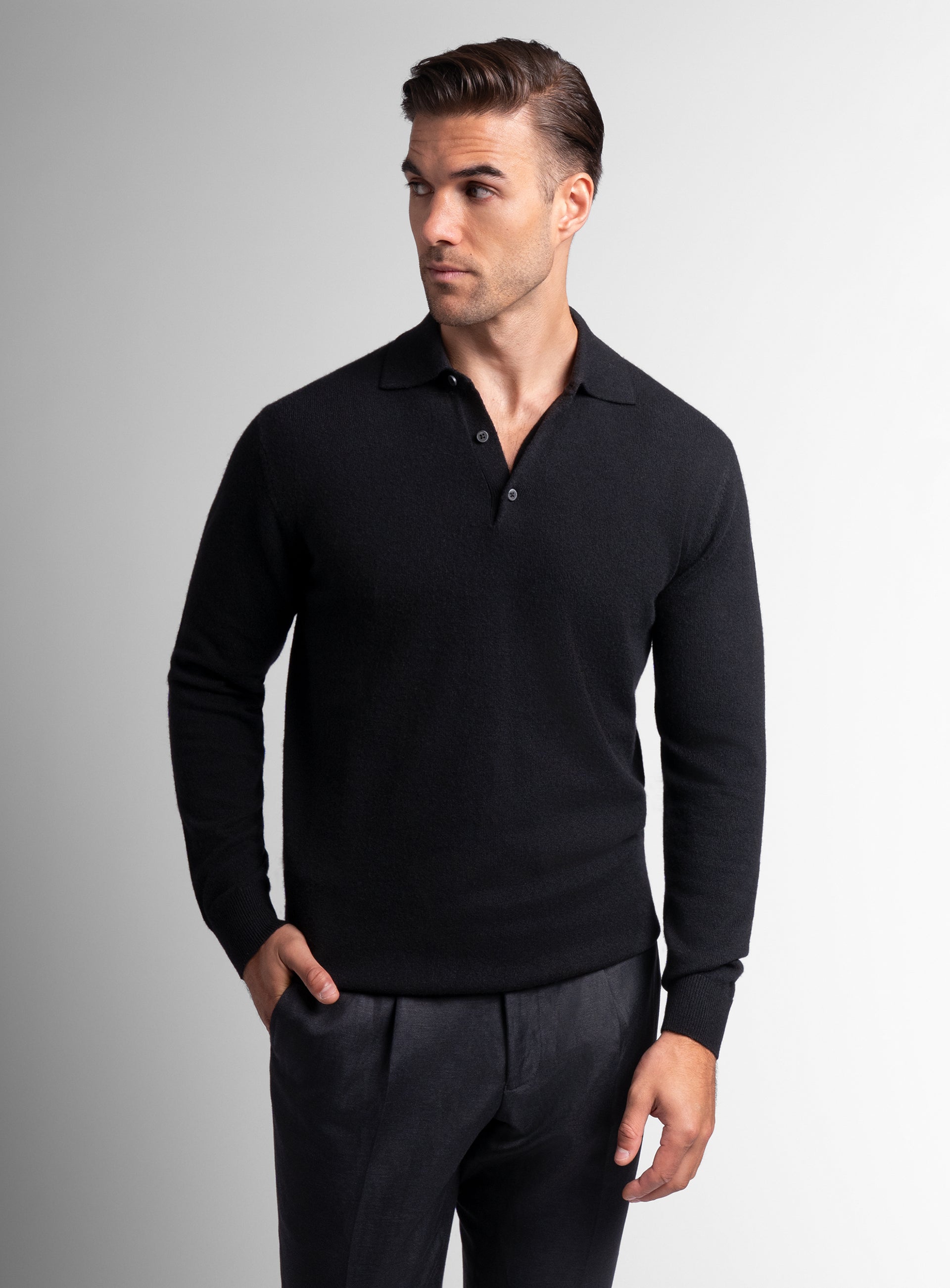Man looking to his side wearing the Wool/Cashmere Long Sleeve Black Polo Knit