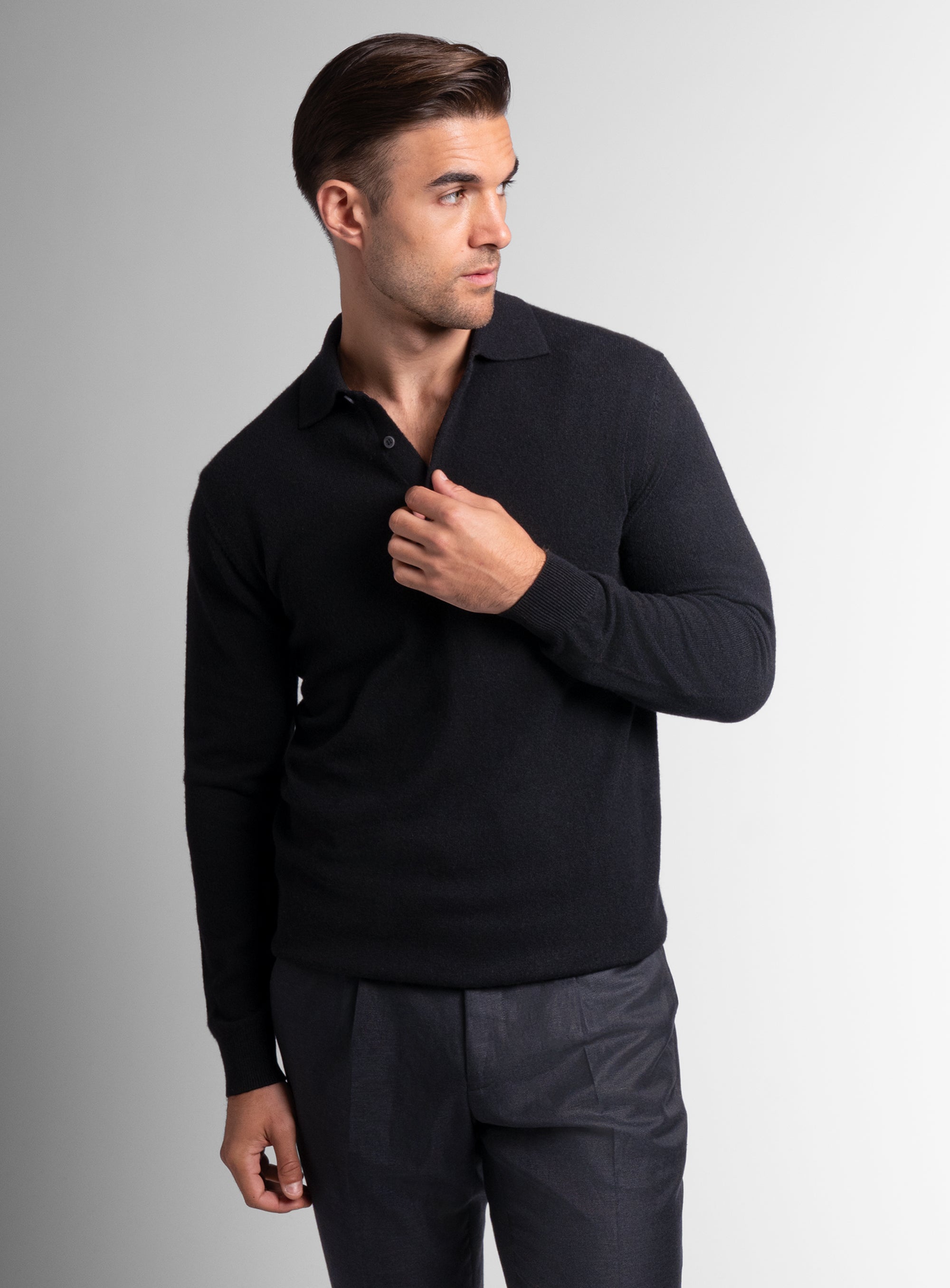 Man holding the buttons on the Wool/Cashmere Long Sleeve Black Polo Knit