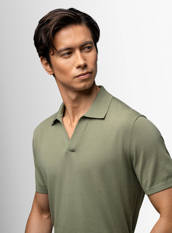 Man wearing a green polo shirt against a light gray background