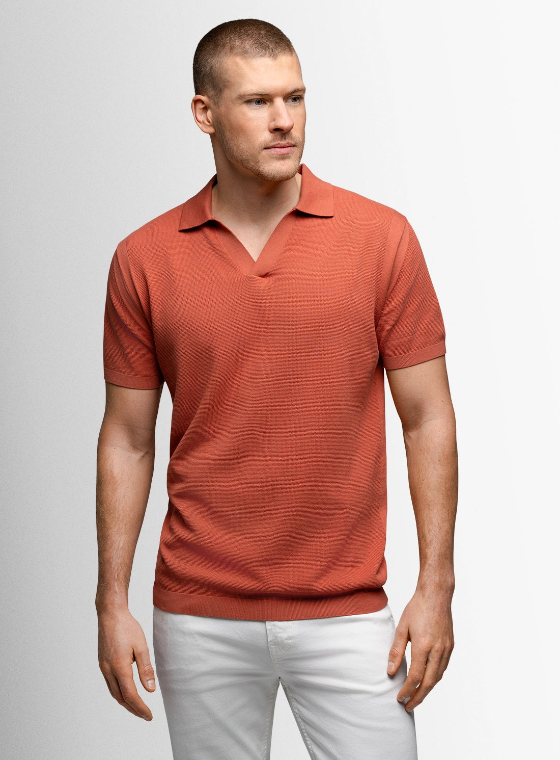 Man wearing a red polo shirt against a plain background