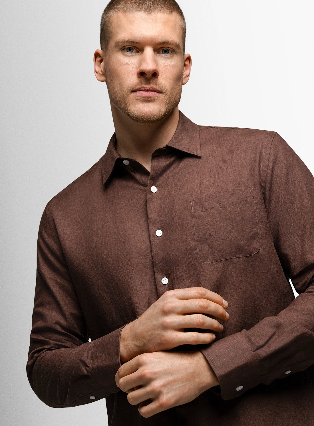 Man wearing a brown shirt against a plain background