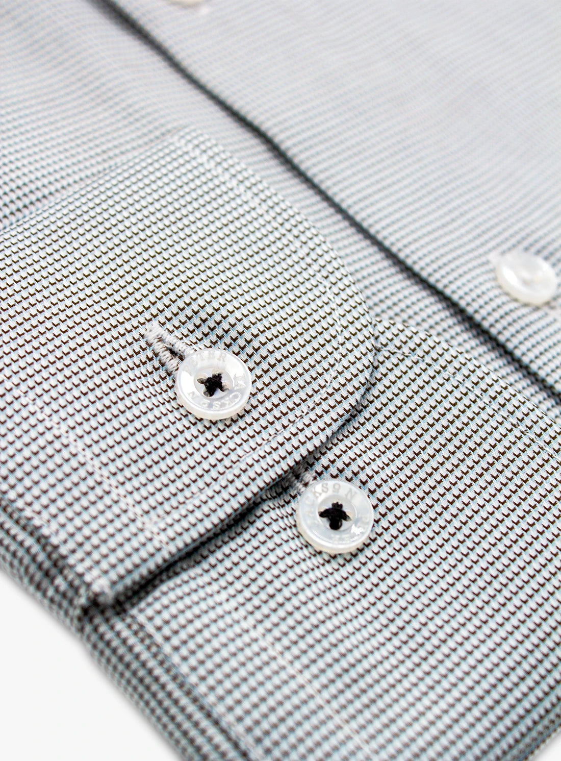 Close-up of a gray textured shirt with buttons on a white background