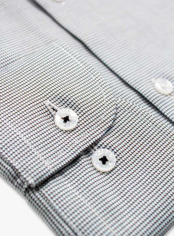 Close-up of a gray textured shirt with buttons on a white background