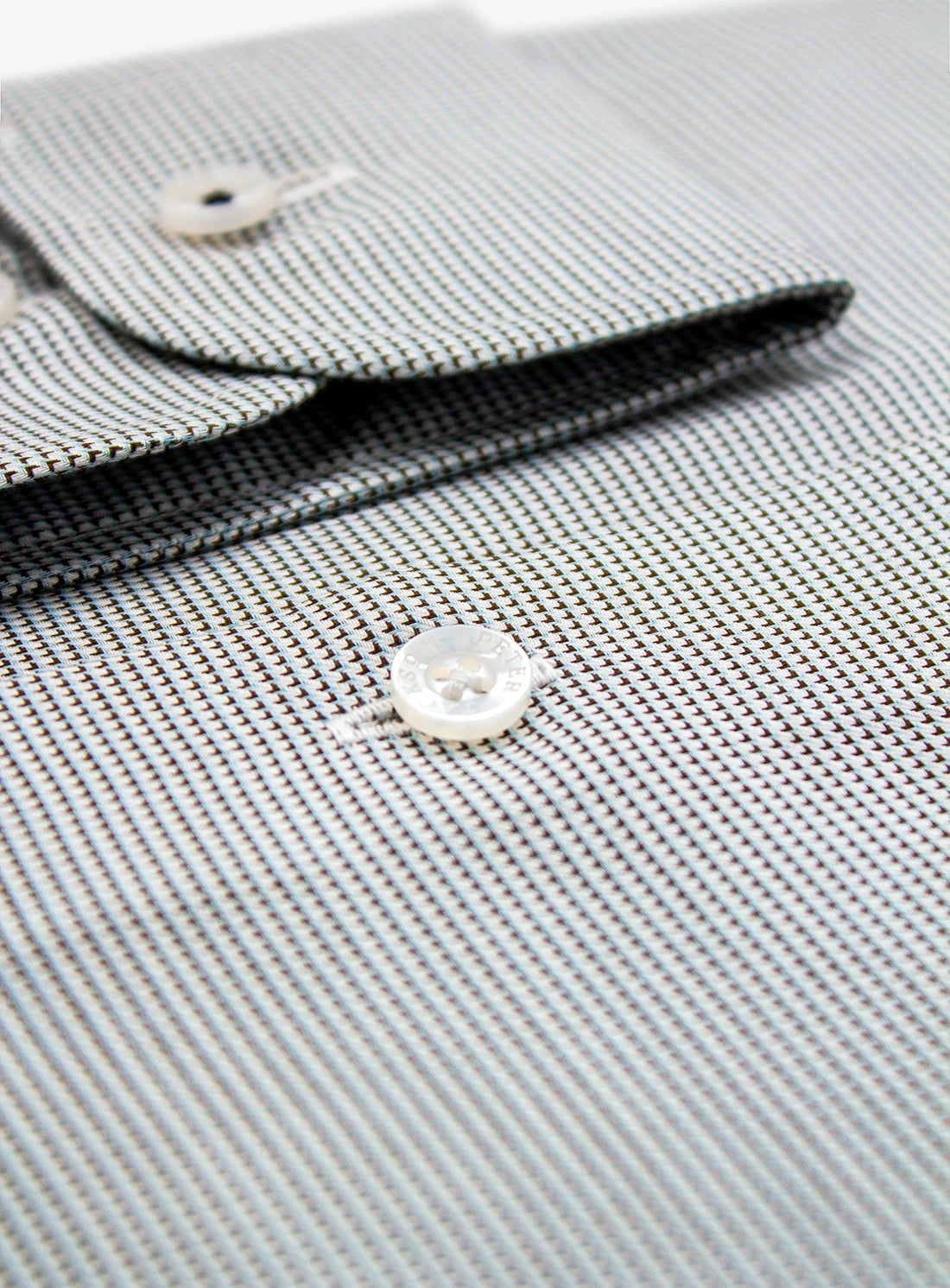 Close-up of a textured fabric with buttons on a light gray background