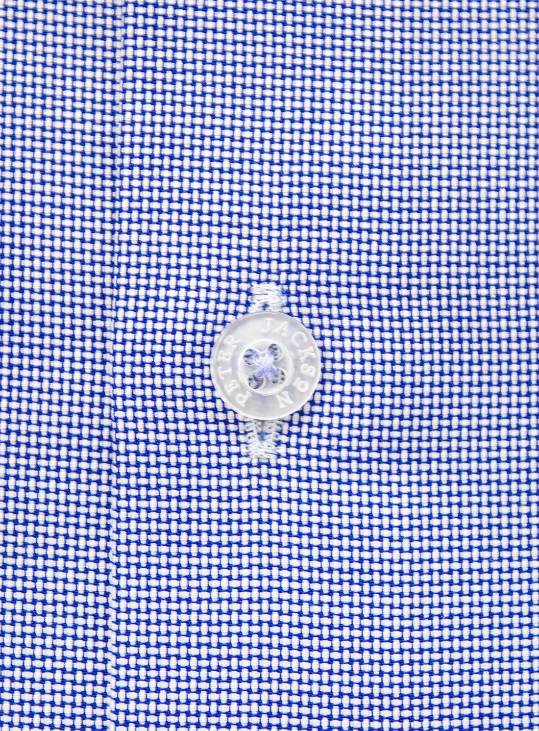 Close-up of a blue checkered fabric with a clear plastic button on a white background