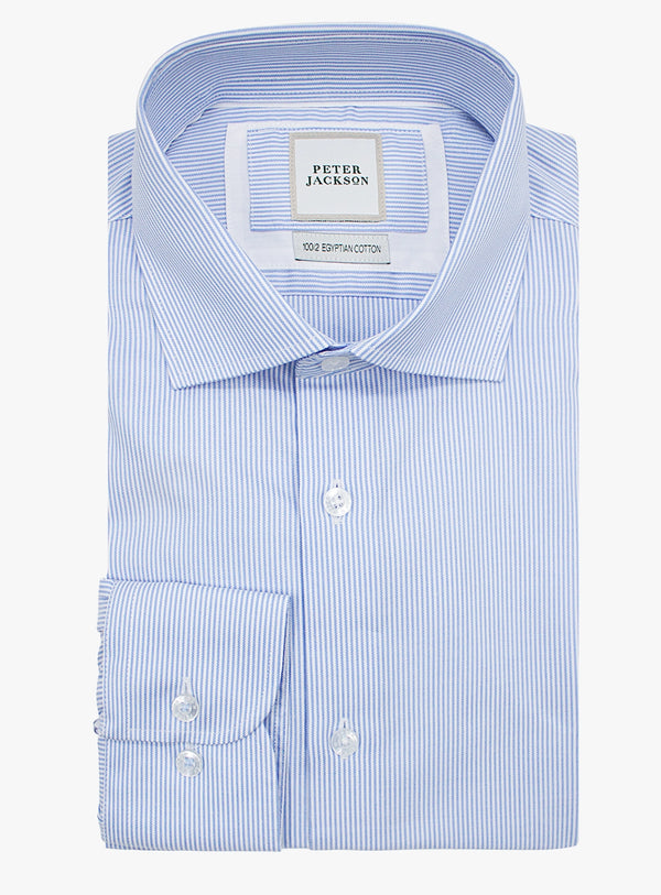 Folded blue and white striped dress shirt with 'Peter Jackson' label on a white background