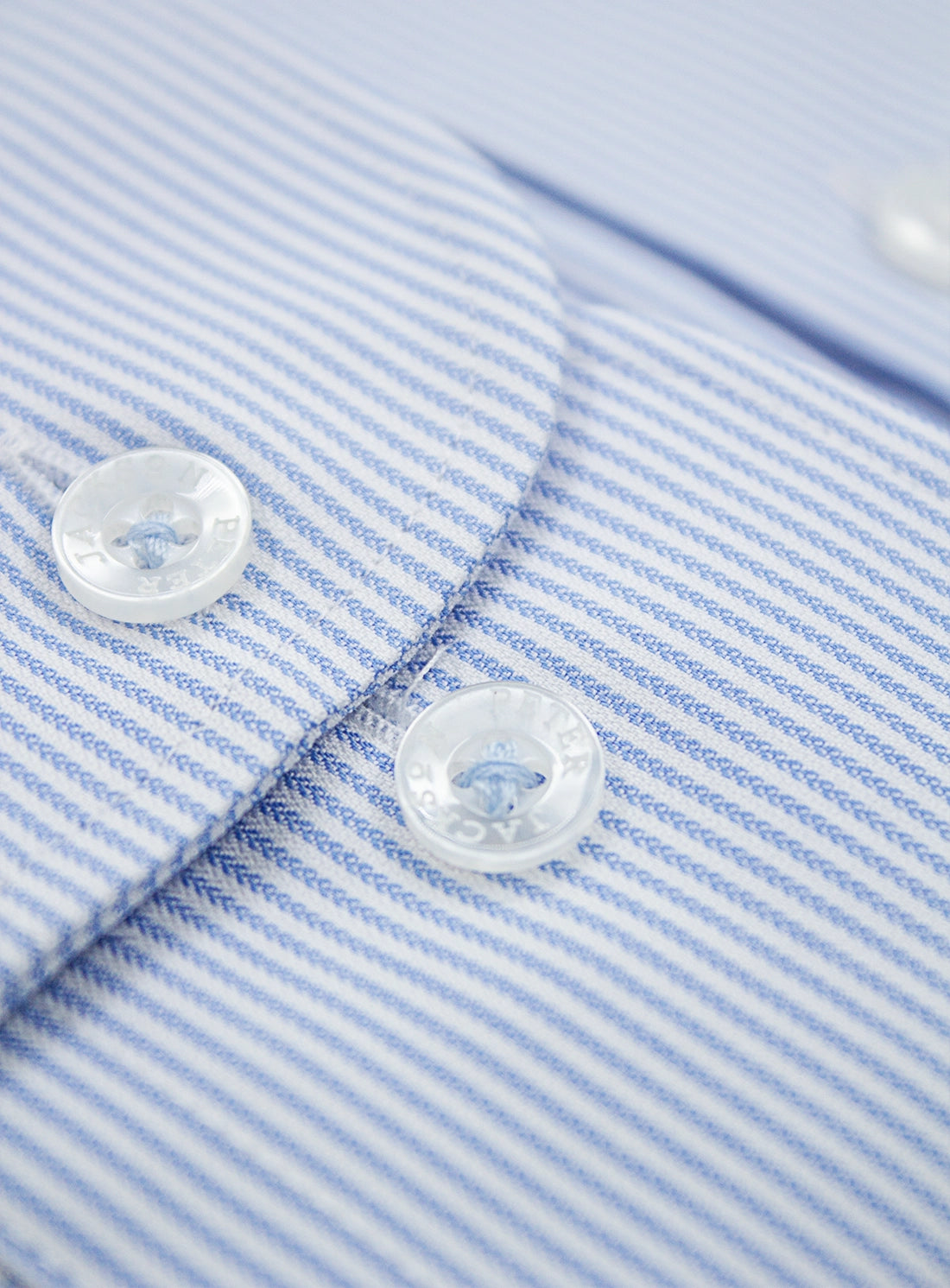 Close-up of a blue and white striped shirt with buttons.