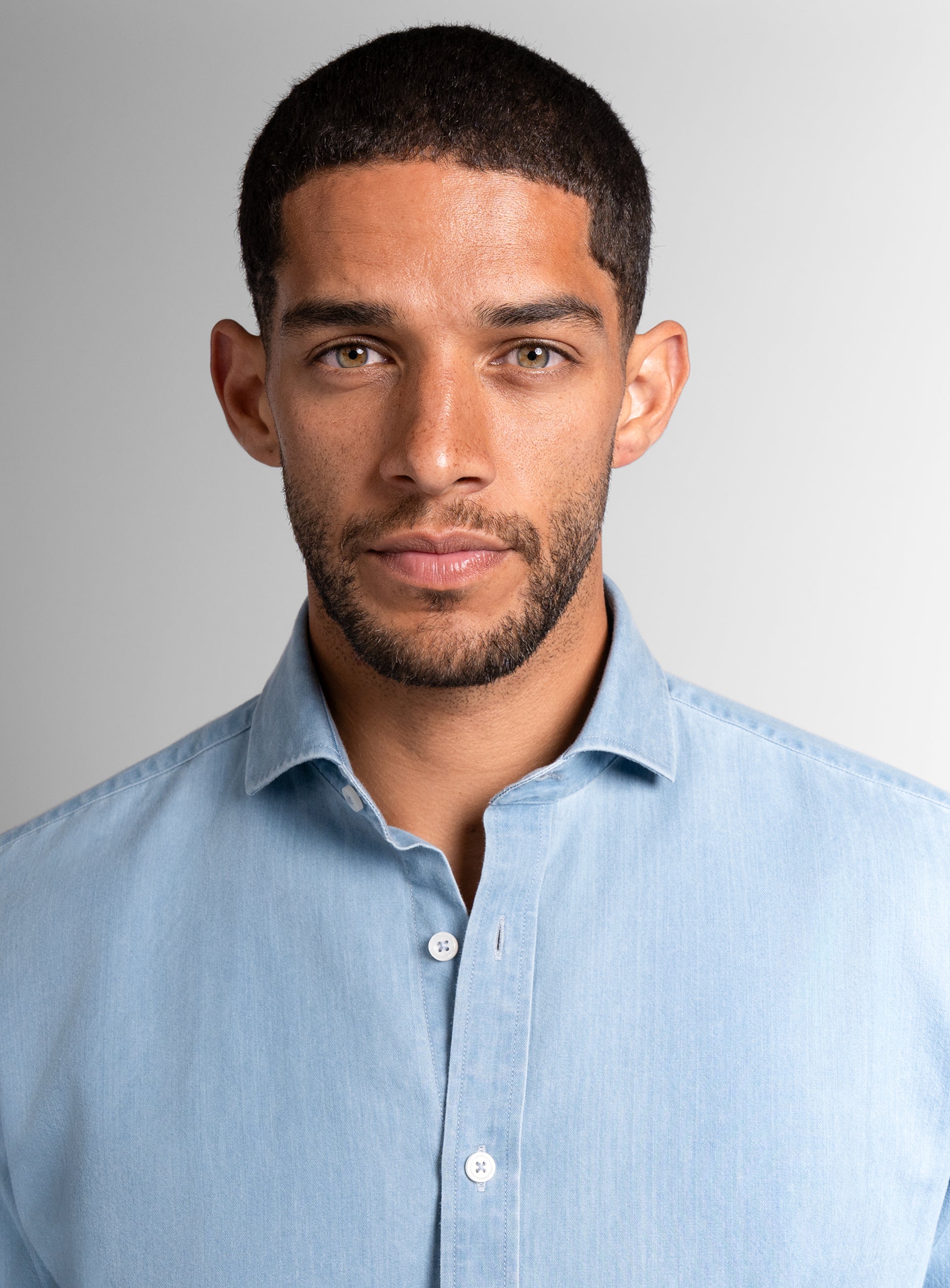 A close-up of a man wearing the Piero Bleachwash Denim Sky Blue Slim Fit Shirt