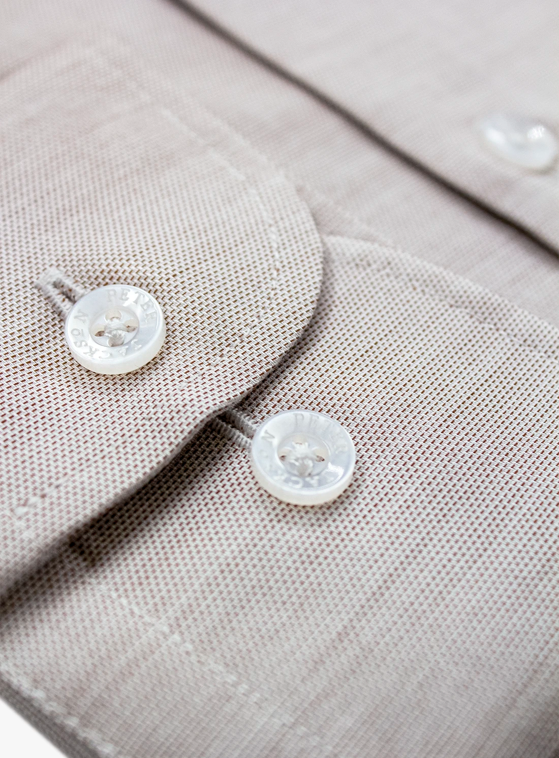 Close-up of a gray shirt with buttons on a light gray background