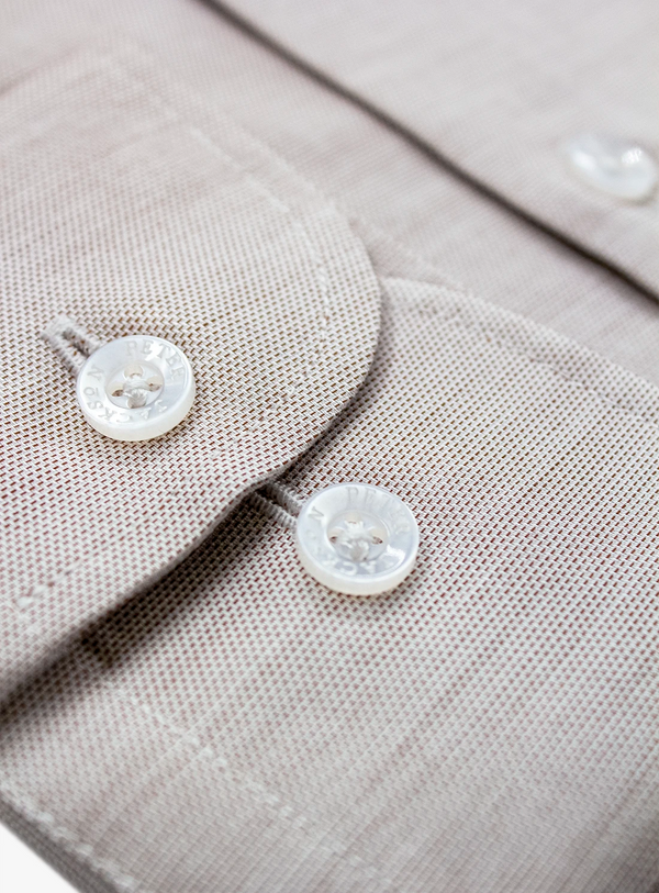 Close-up of a gray shirt with buttons on a light gray background