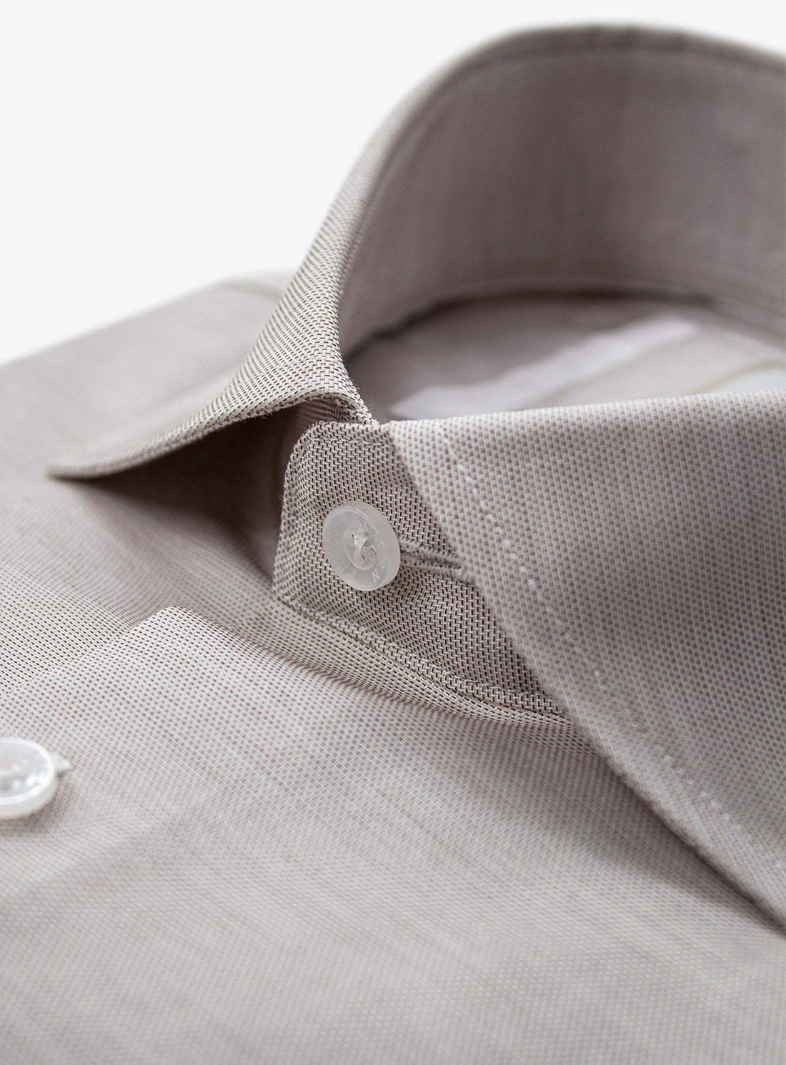 Close-up of a gray shirt collar with buttons on a white background