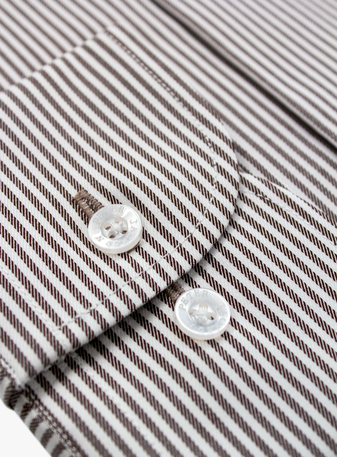 Close-up of a shirt with button details on a striped background