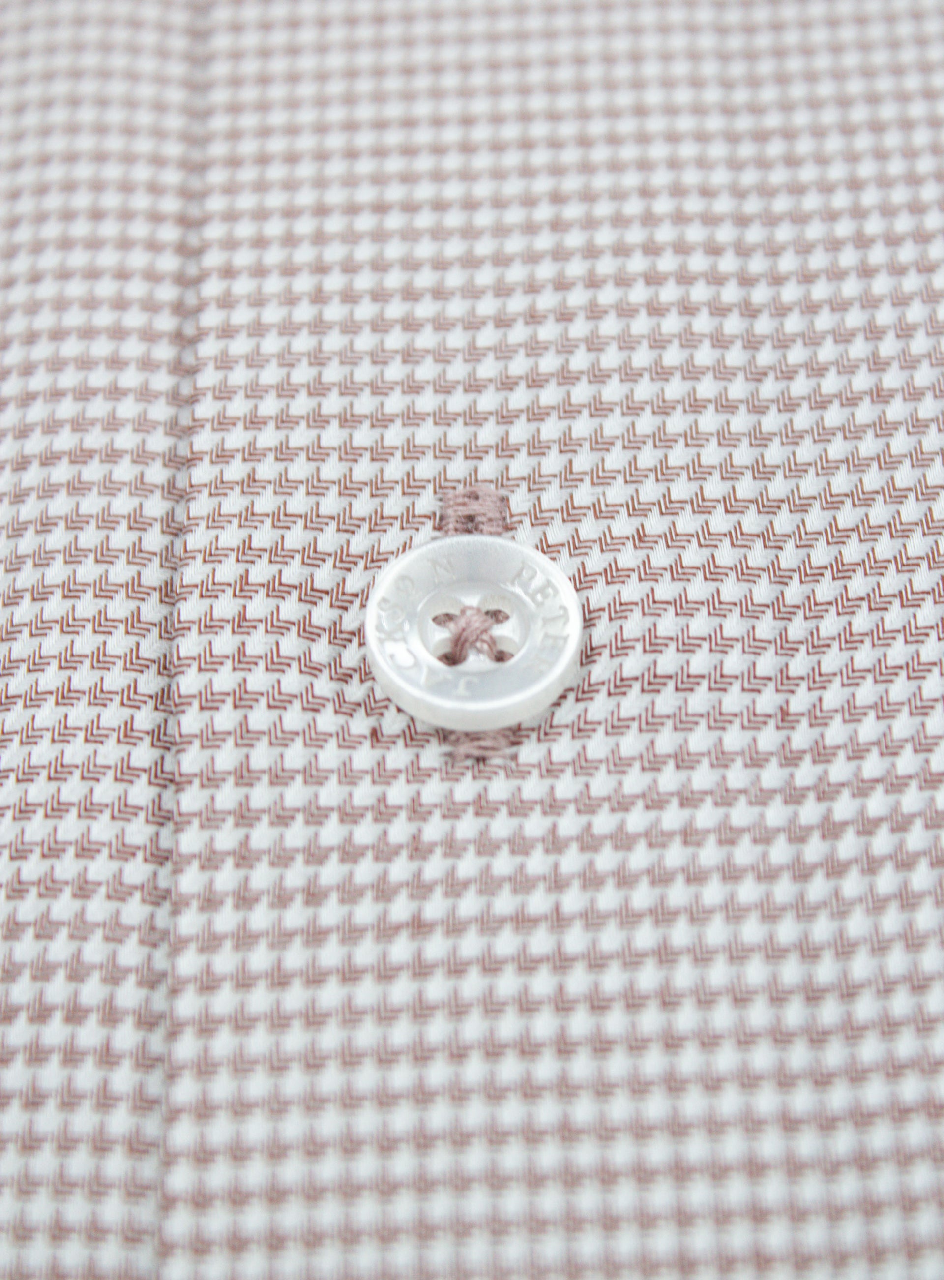 Close-up of a button on the Milan Brown Puppytooth Shirt