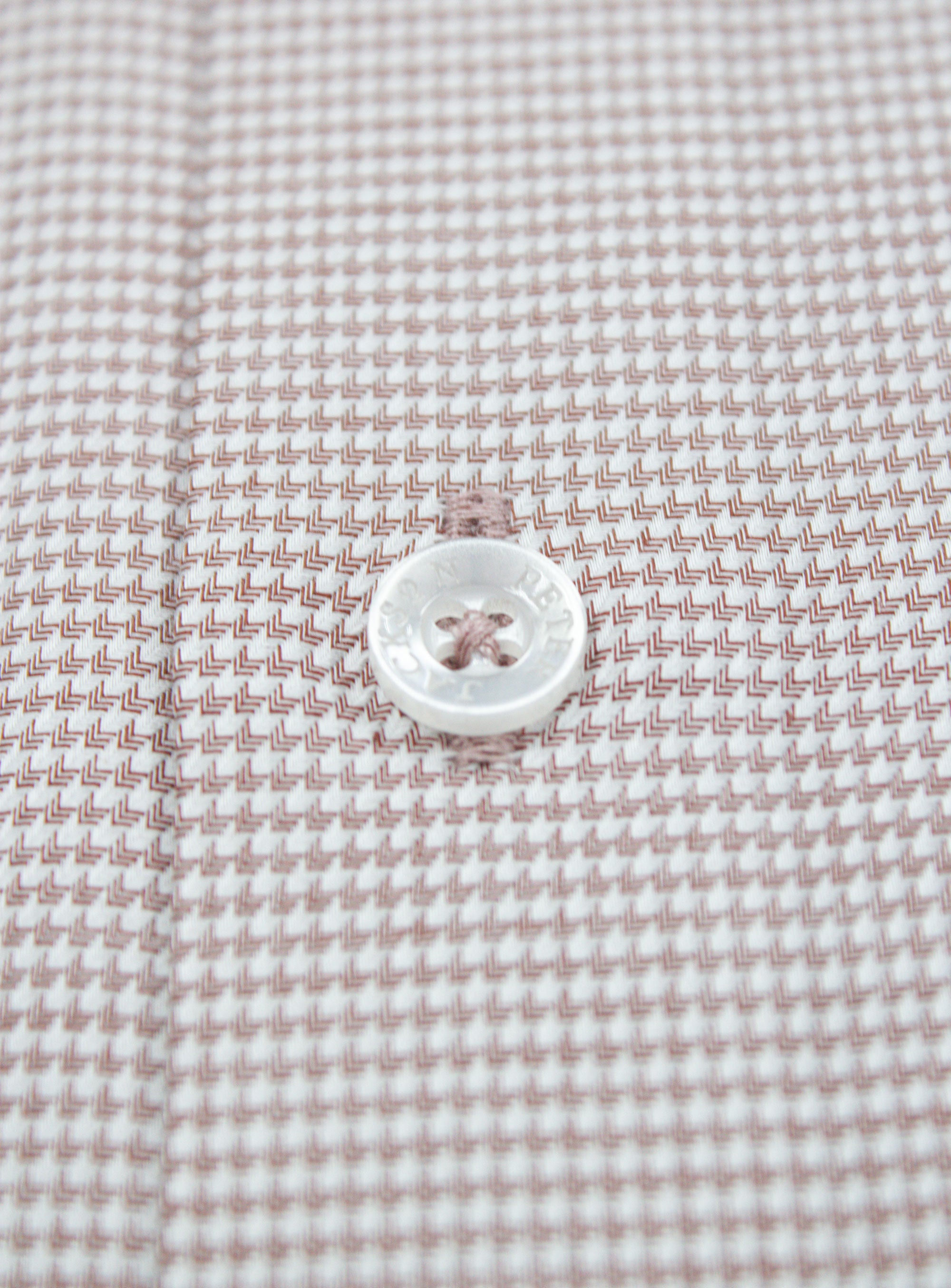 Close-up of a button on the Milan Brown Puppytooth Shirt