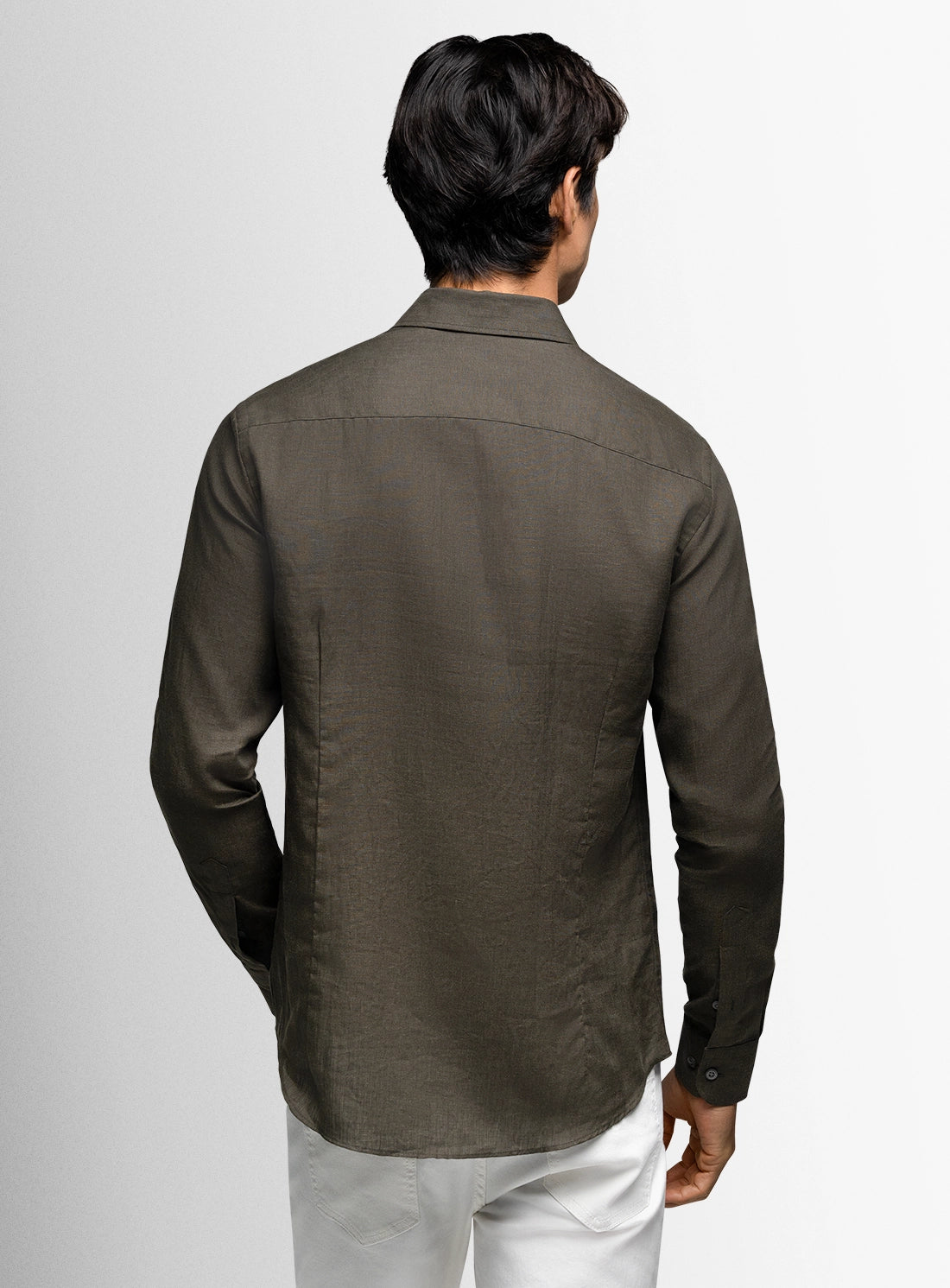 Man wearing a dark brown shirt with a plain background