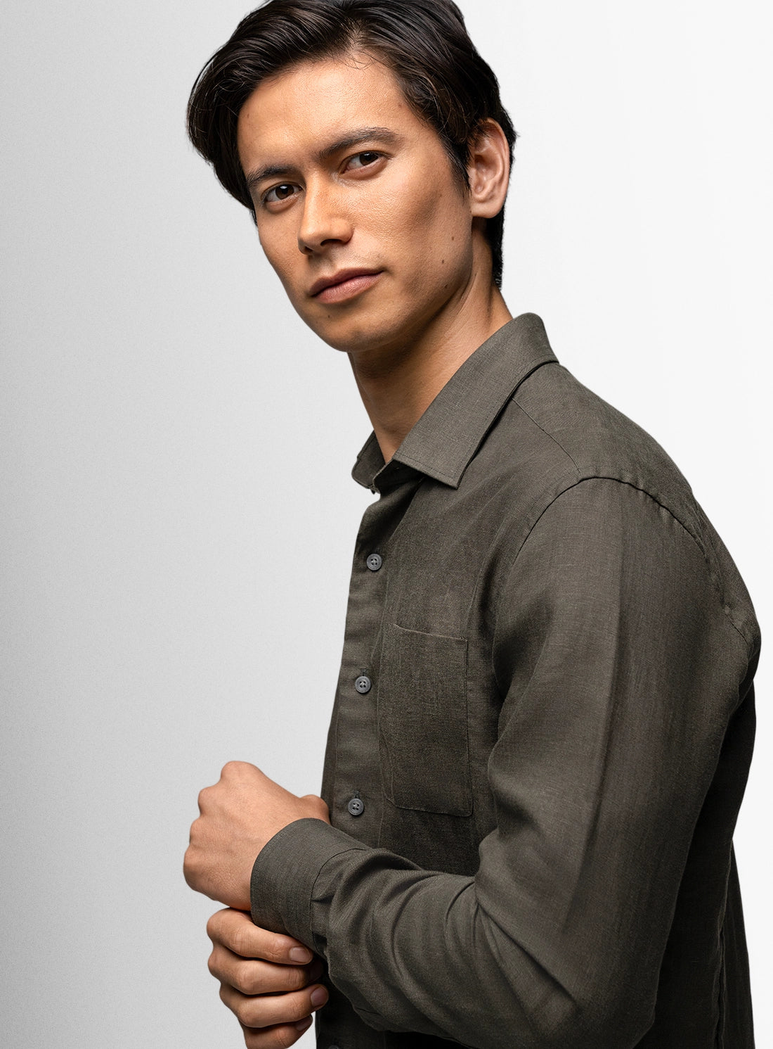 Man wearing a dark green shirt against a plain background