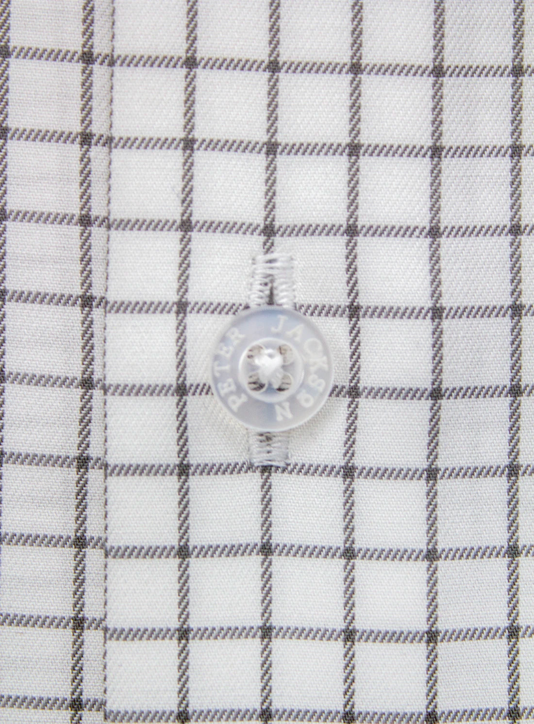 Close-up of a button on a checkered shirt with a white background