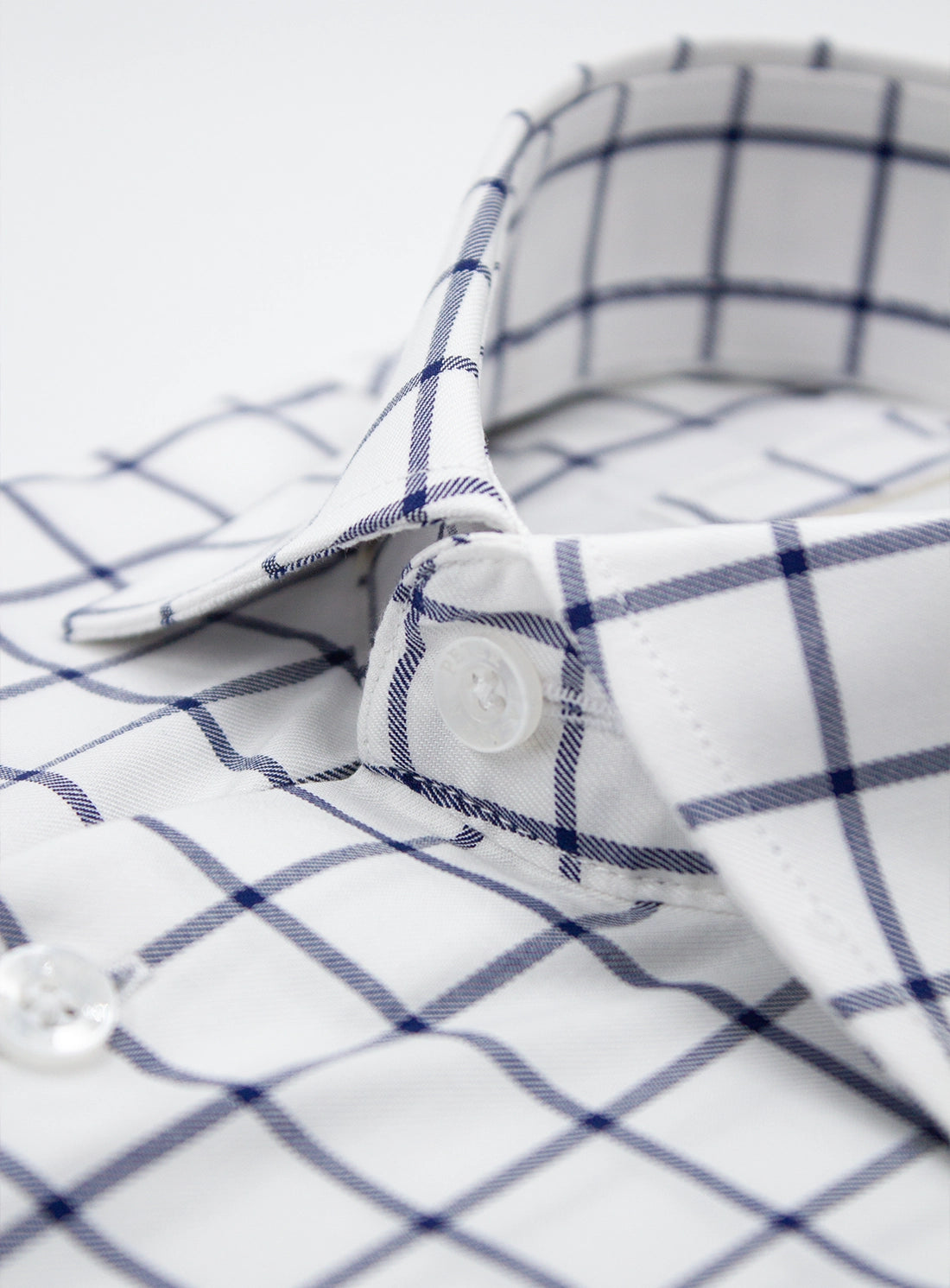 Close-up of a white shirt with blue checkered pattern on a white background