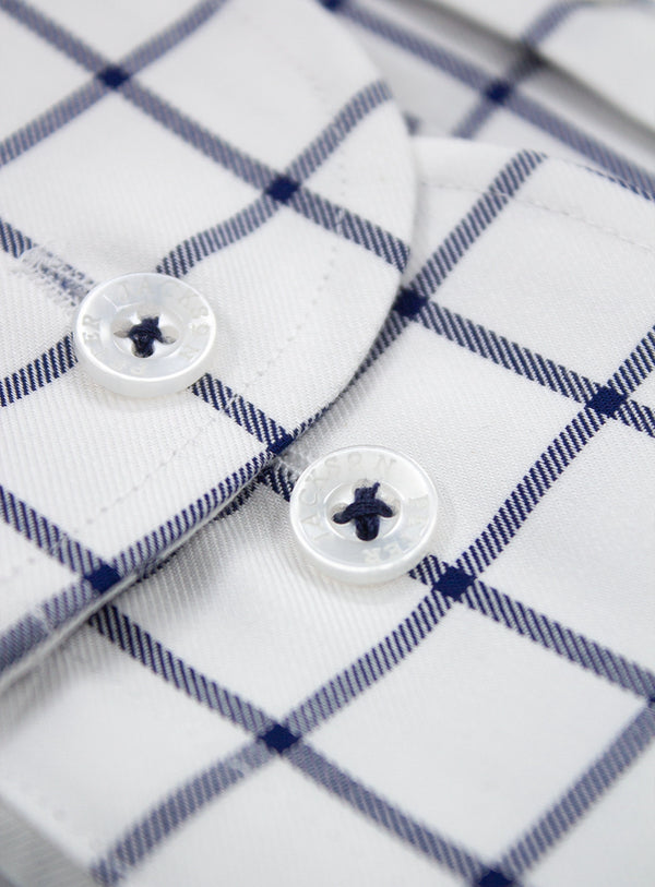 Close-up of a white shirt with blue plaid pattern and buttons.