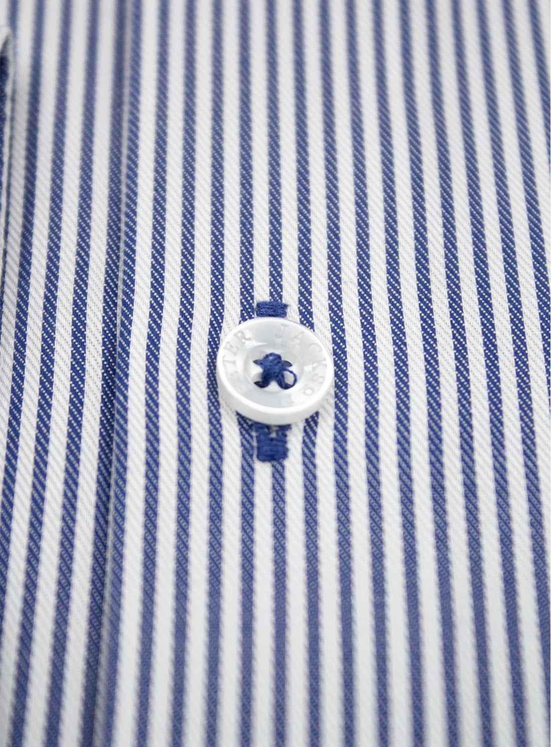 Close-up of a blue and white striped shirt with a button.