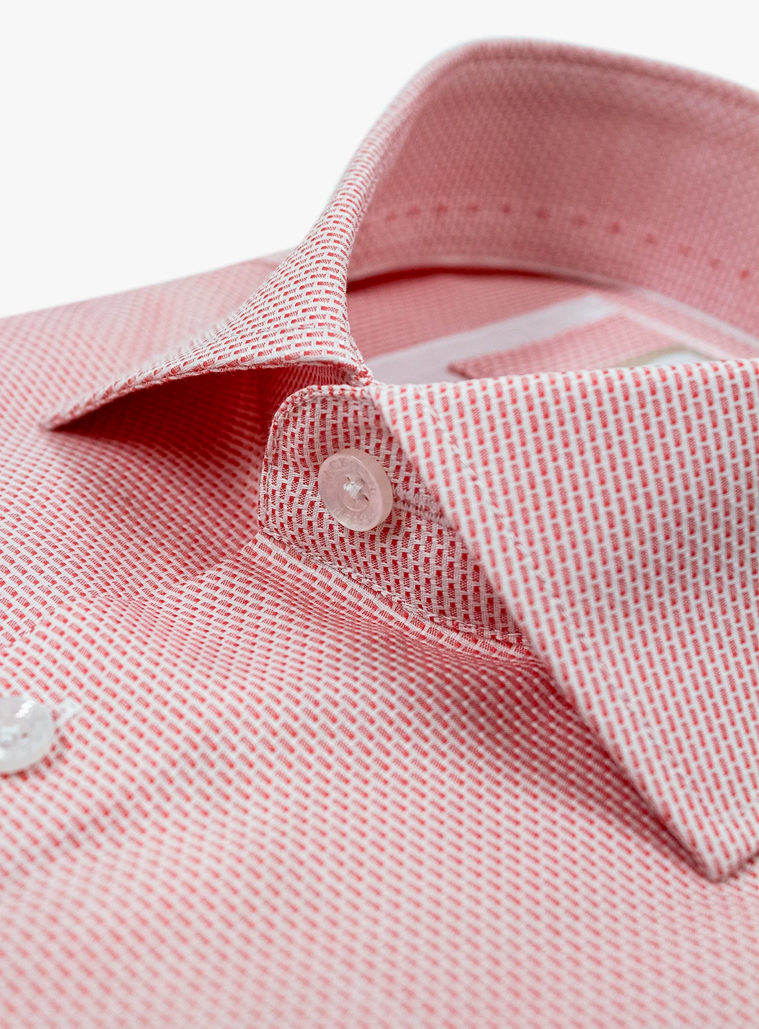 Close-up of a pink textured shirt with buttons on a white background