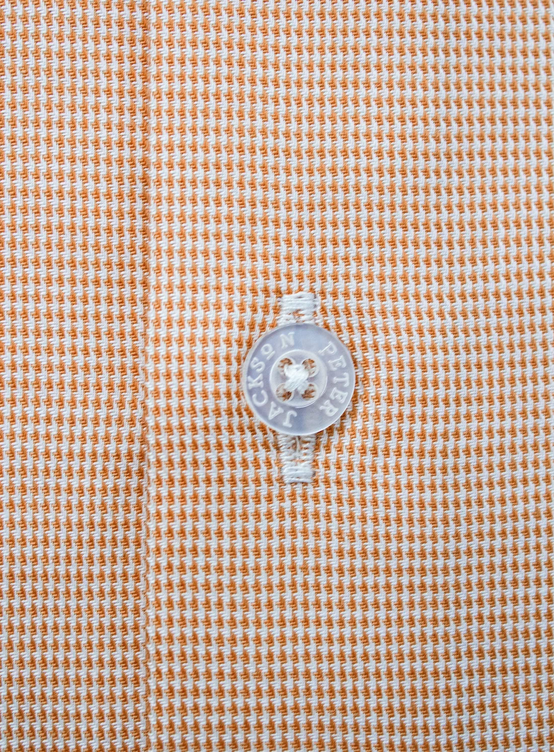 Close-up of a button on a brown checkered fabric