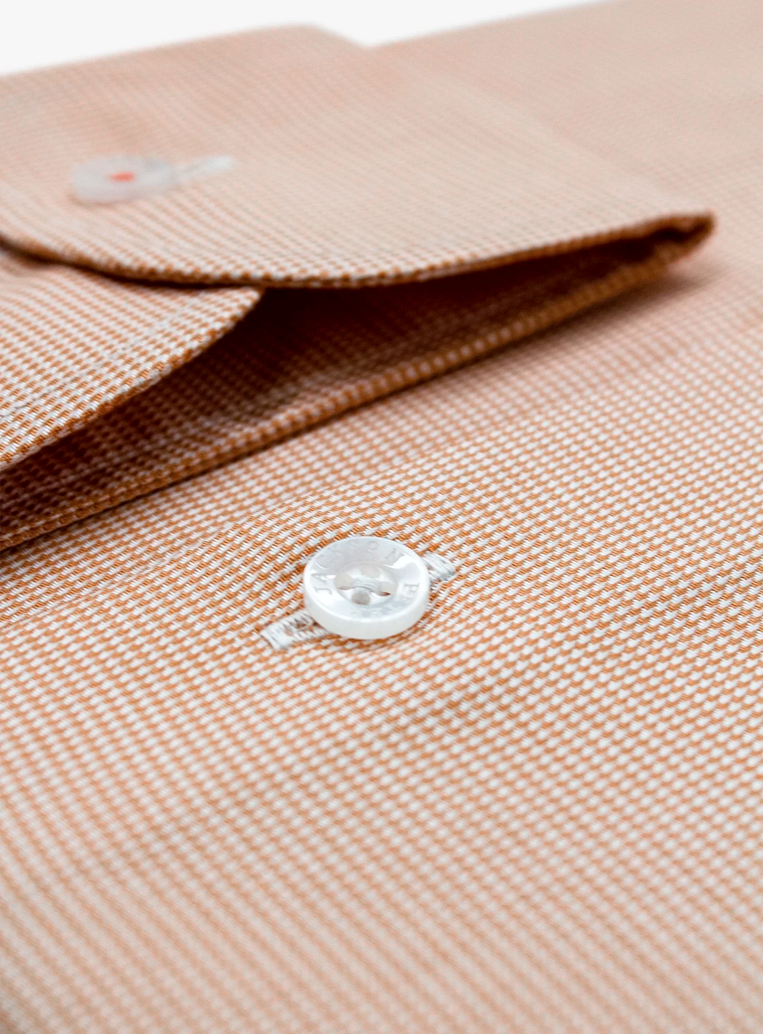 Close-up of a beige textured fabric with a button