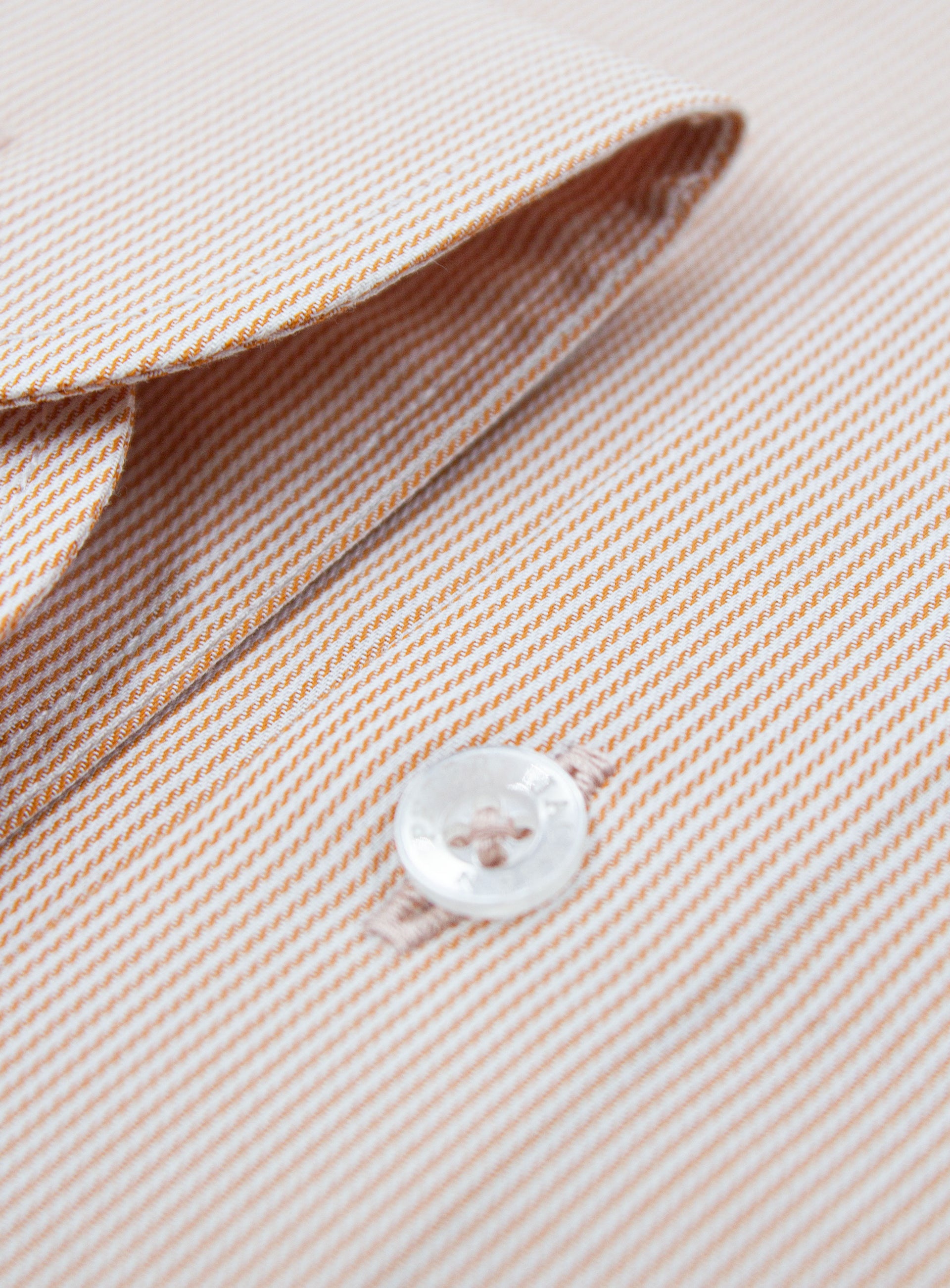 Close-up of a button on the Milan Fine Stripe Orange Shirt