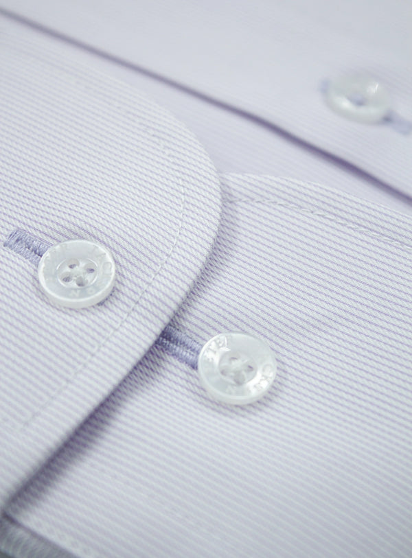 Close-up of a light purple shirt with buttons on a matching fabric background