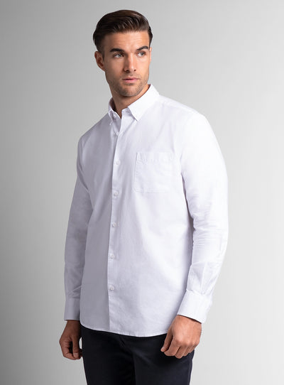 Man wearing a white dress shirt against a gray background