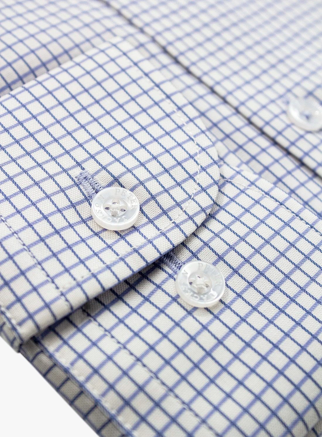 Close-up of a blue and white checkered shirt with buttons.
