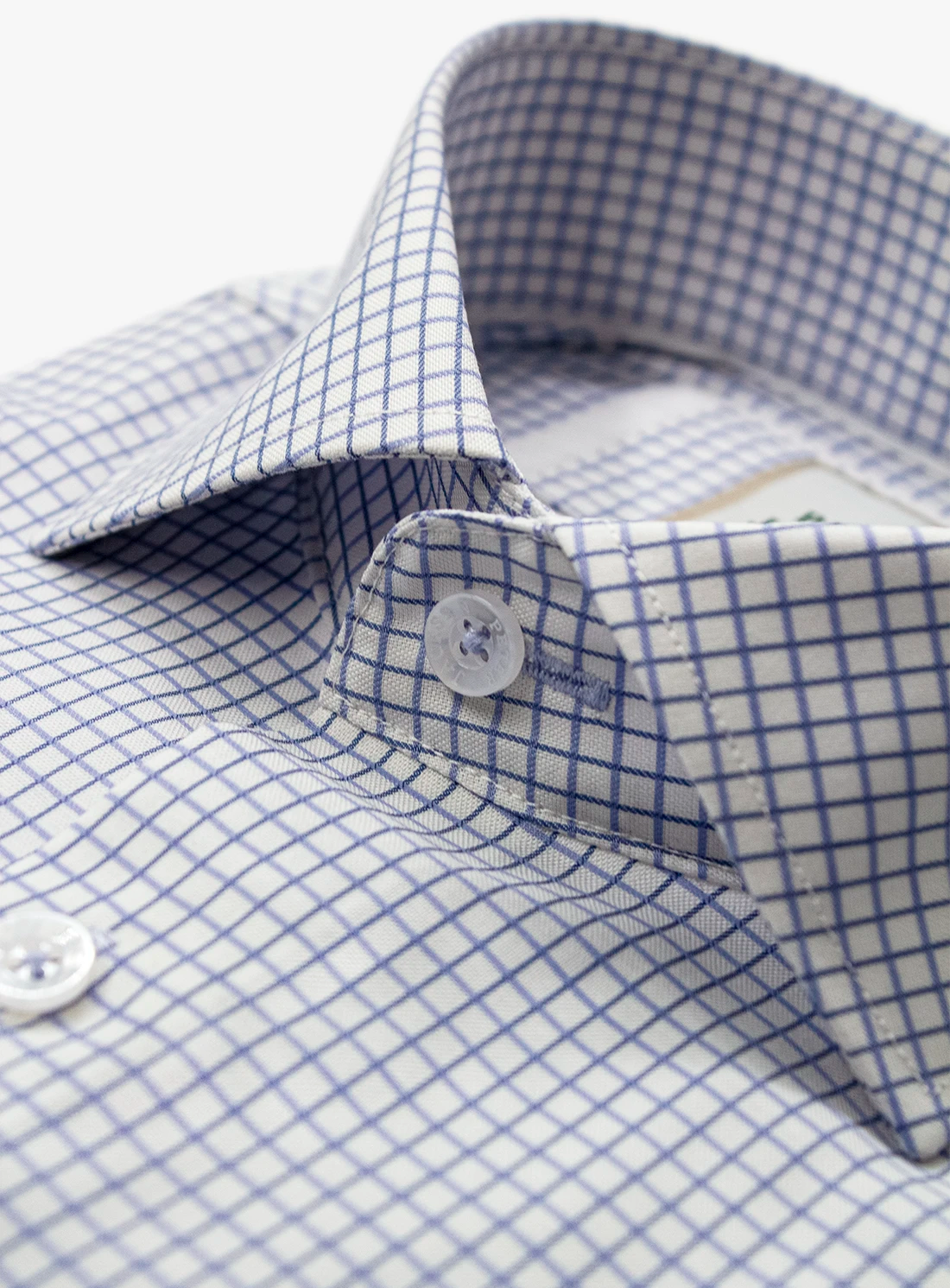Close-up of a blue and white checkered shirt with a button.