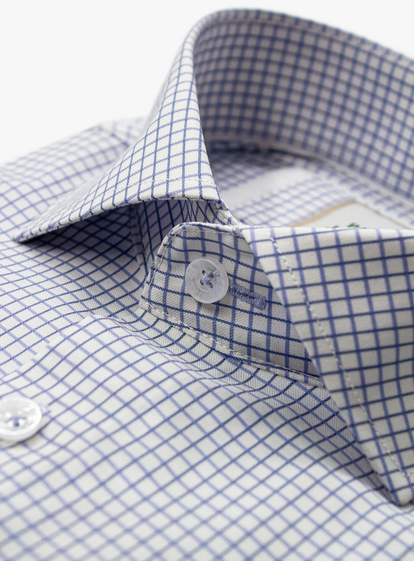 Close-up of a blue and white checkered shirt with a button.