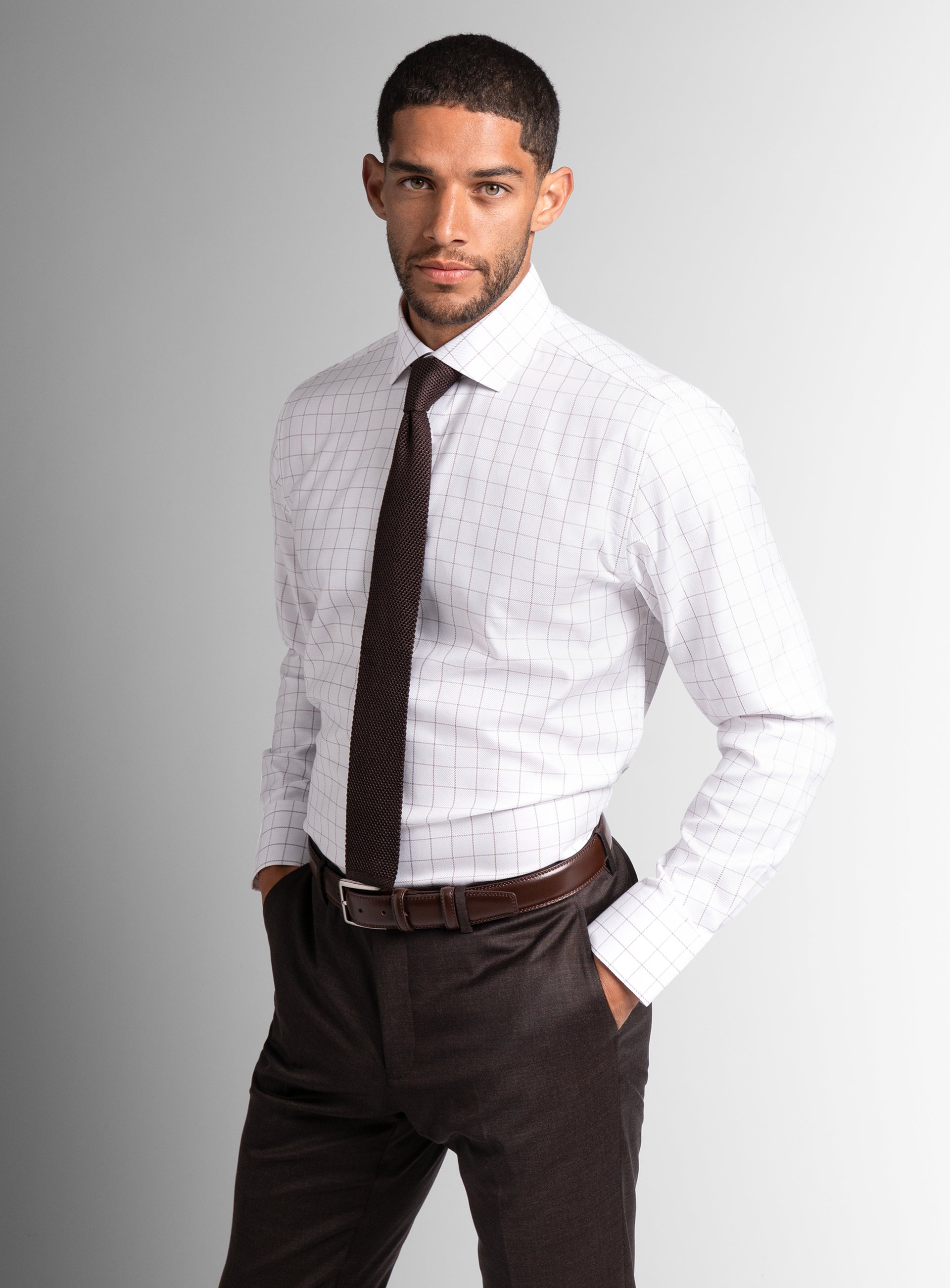 Man with his hands in his pockets, wearing the Milan Twill Brown Mid-Check White Shirt