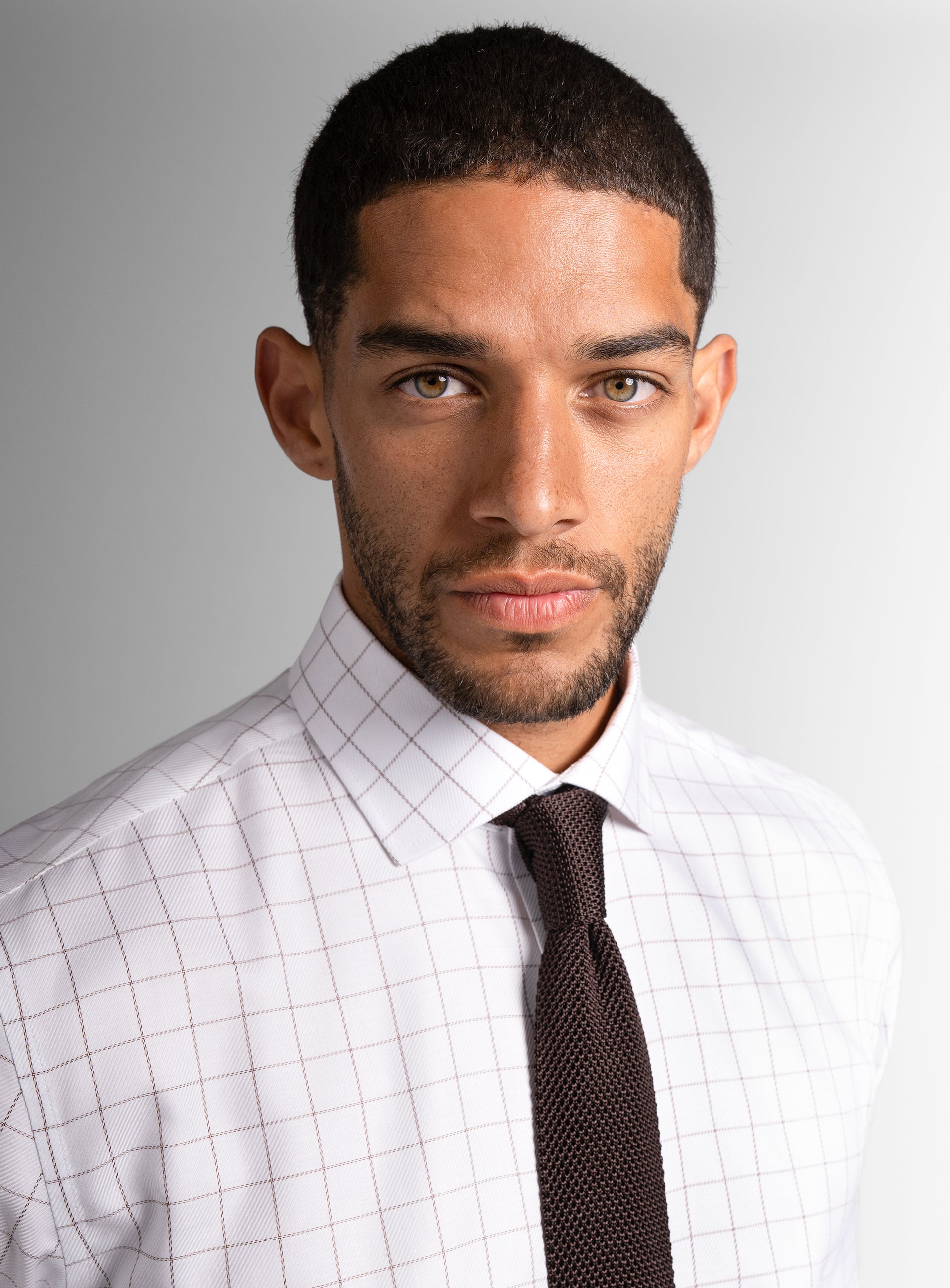 Close-up of a man wearing the Milan Twill Brown Mid-Check White Shirt