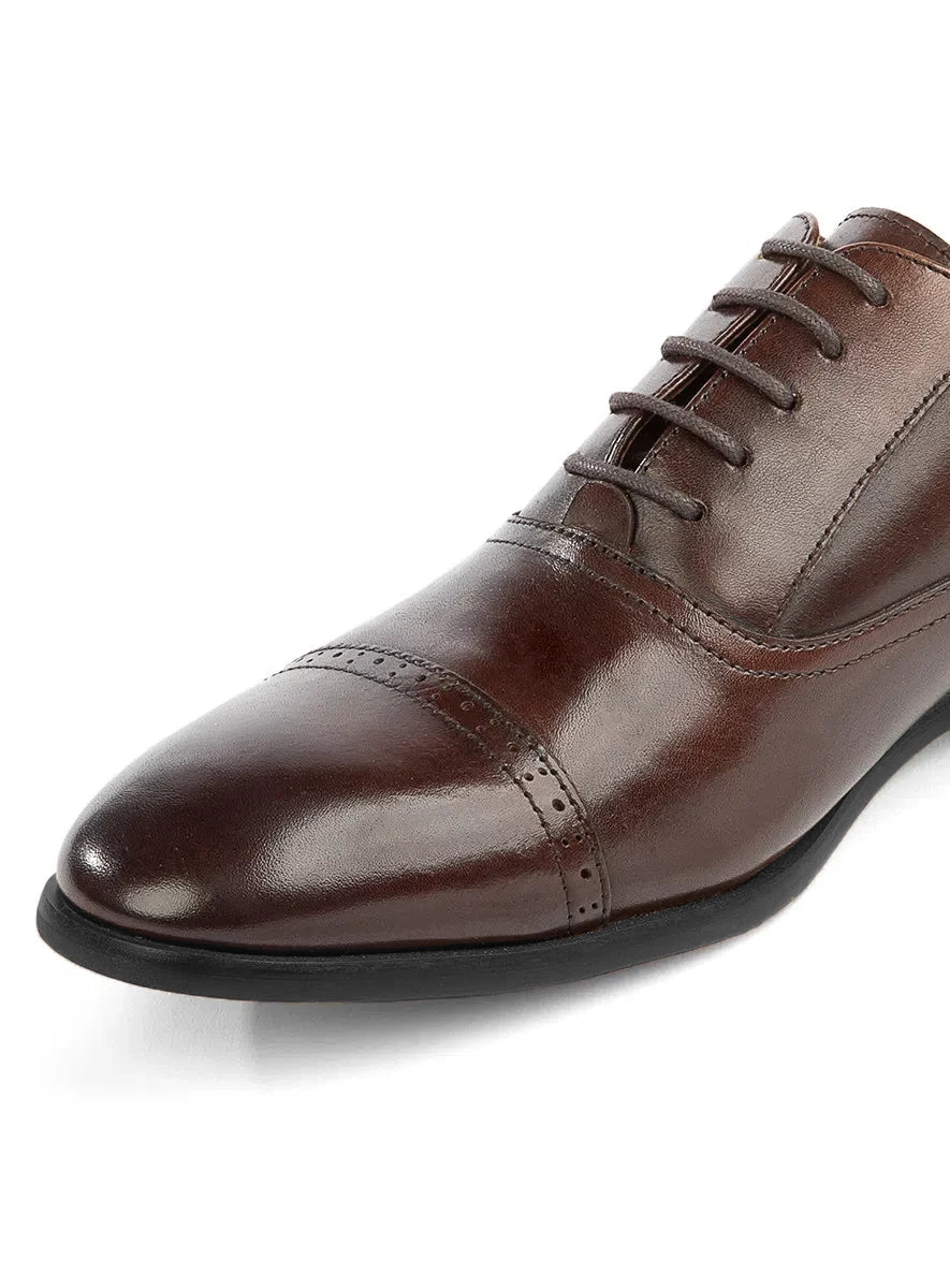 Brown leather dress shoe on a white background