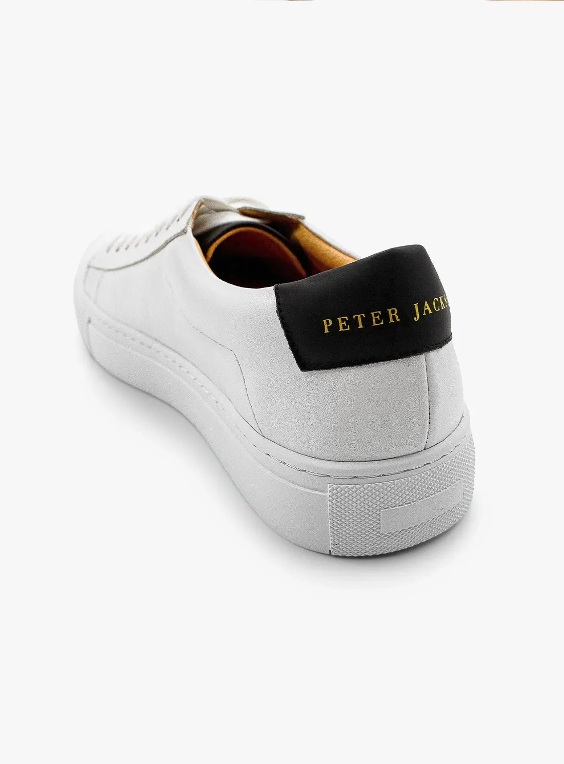 White sneaker with a black band featuring 'Peter Jackson' branding on a white background