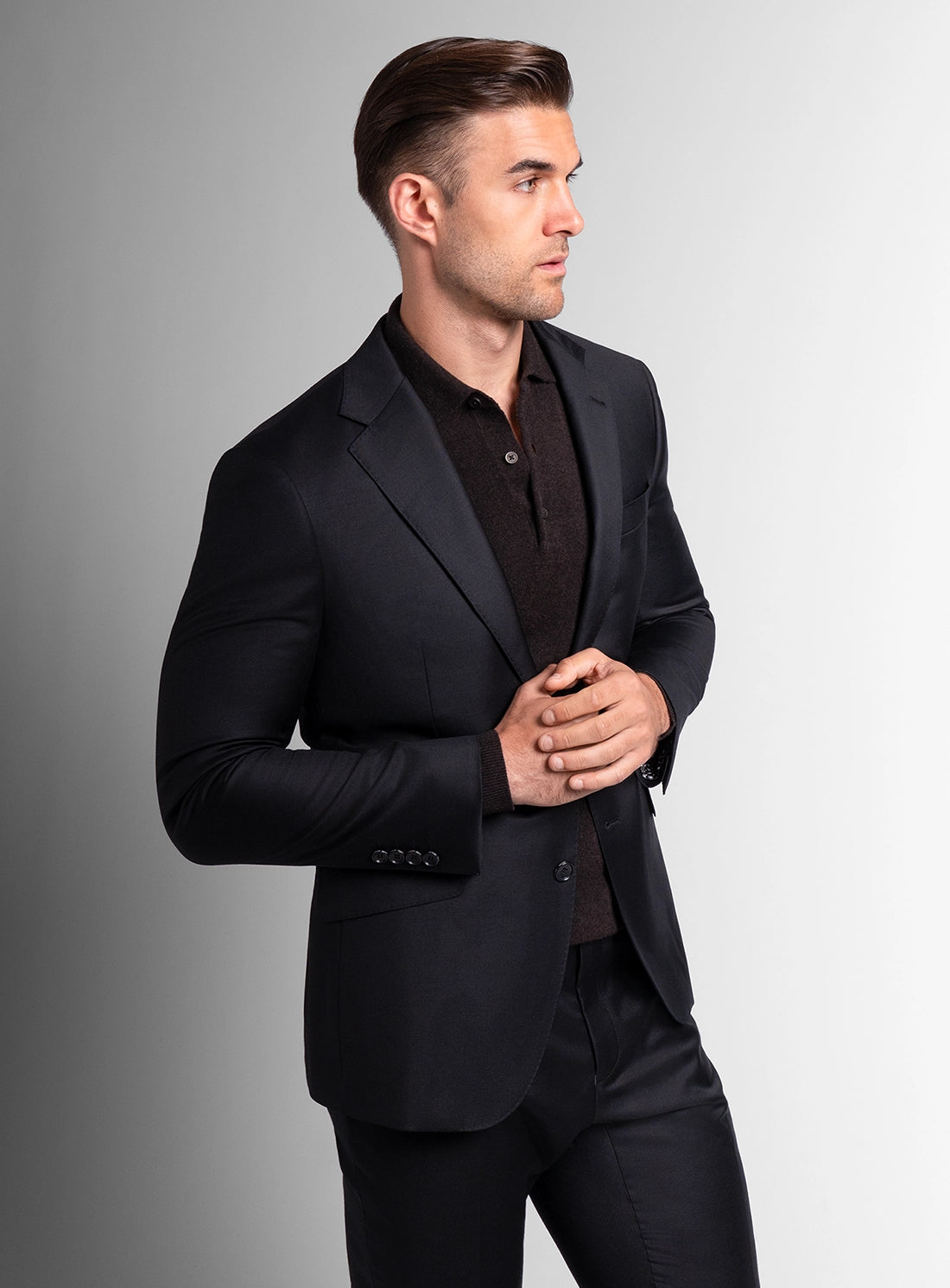 Man wearing a black suit against a gray background