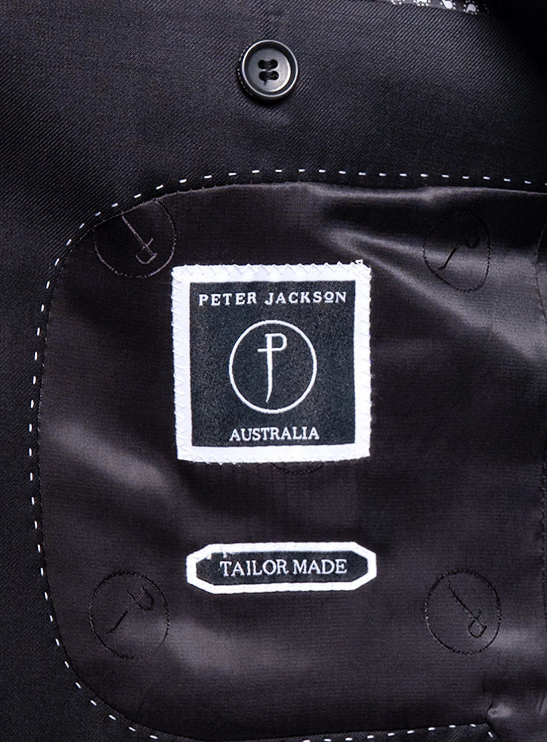 Close-up of a 'Peter Jackson Australia' label on a black garment.