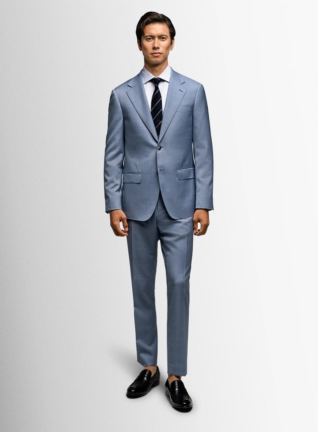 Man wearing a light blue suit with a striped tie on a white background