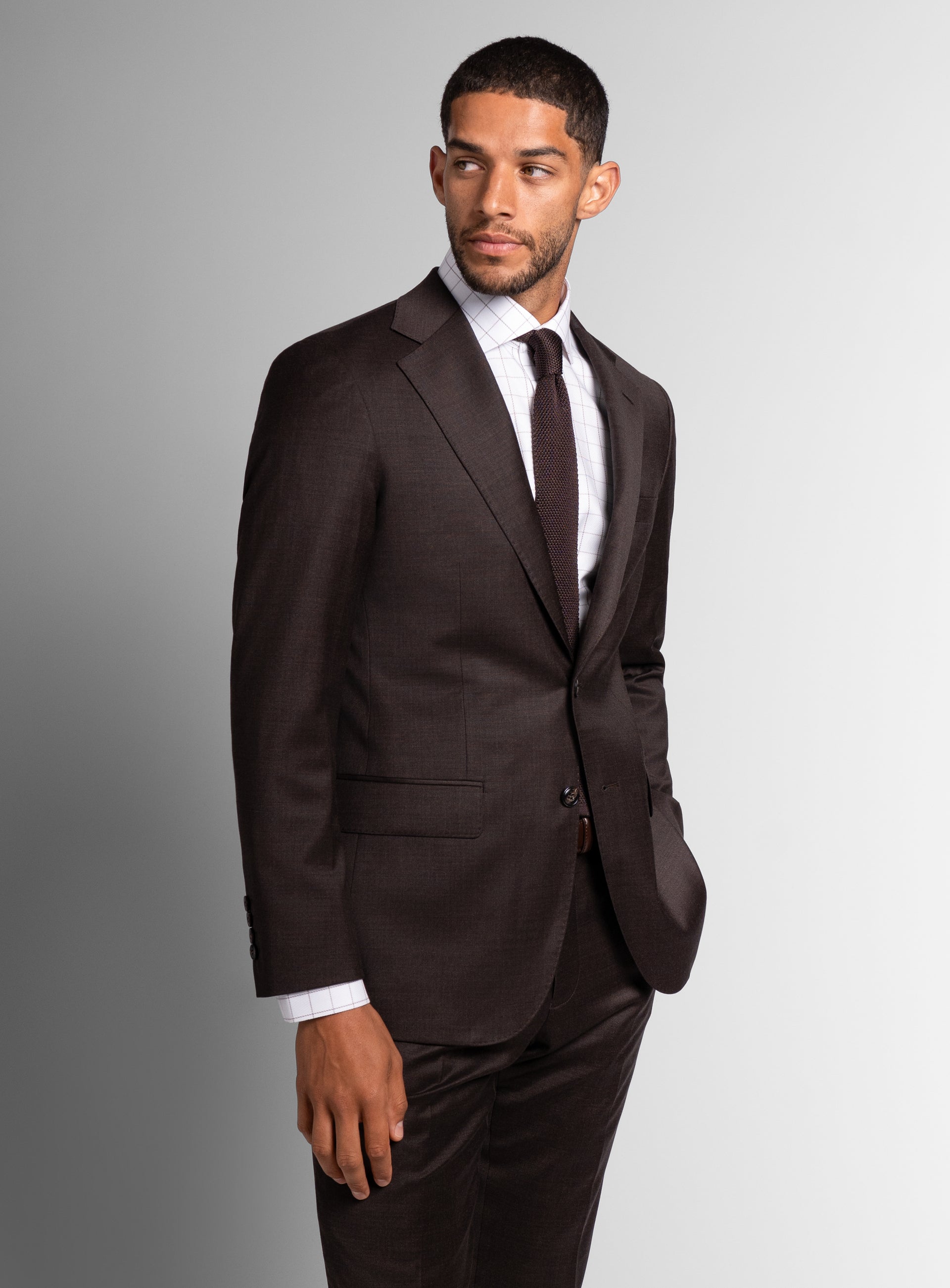 Man looking to his side while wearing the Vespucci Sharkskin Chocolate Brown Suit