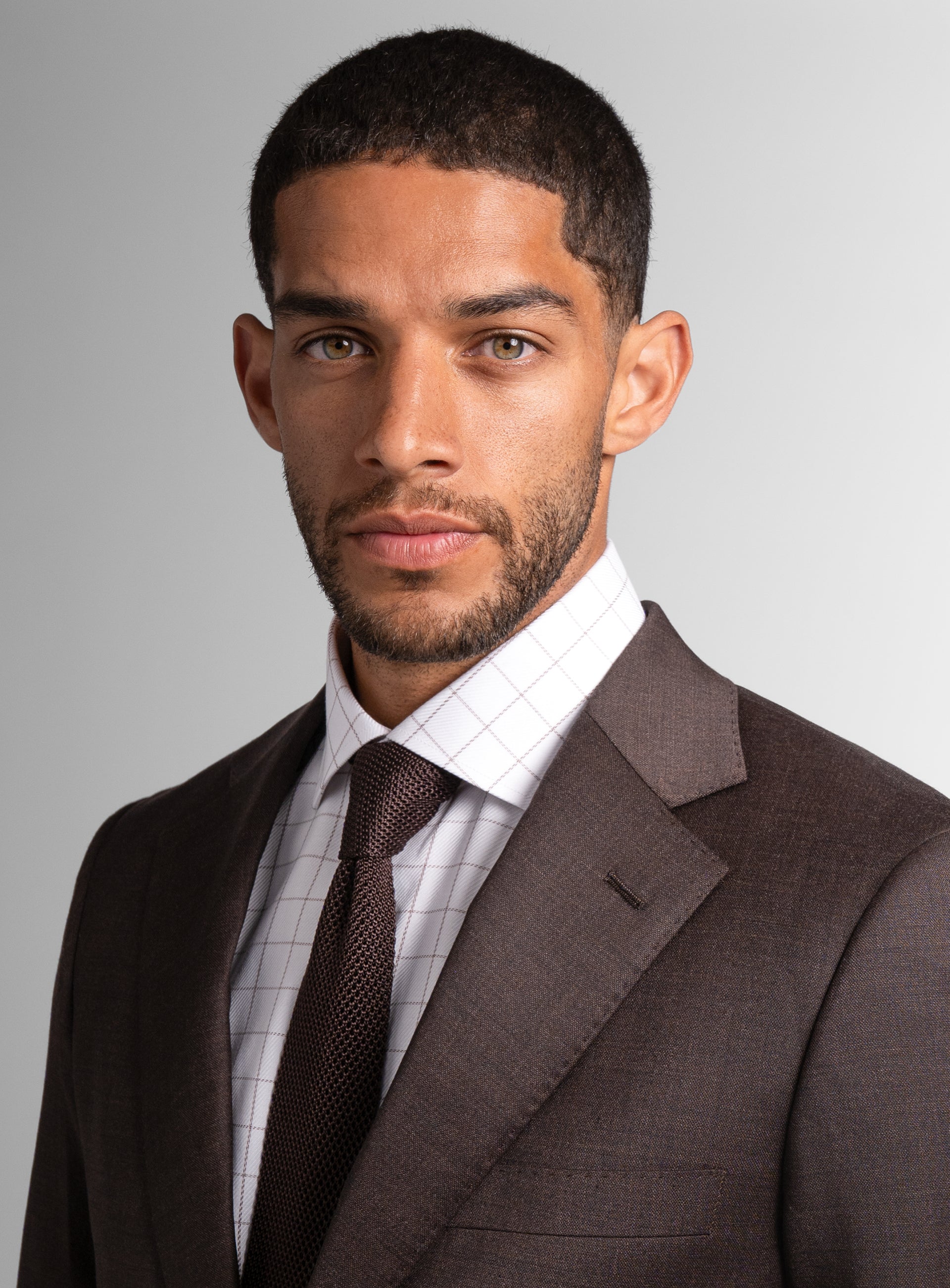Close-up of a man wearing the Vespucci Sharkskin Chocolate Brown Suit