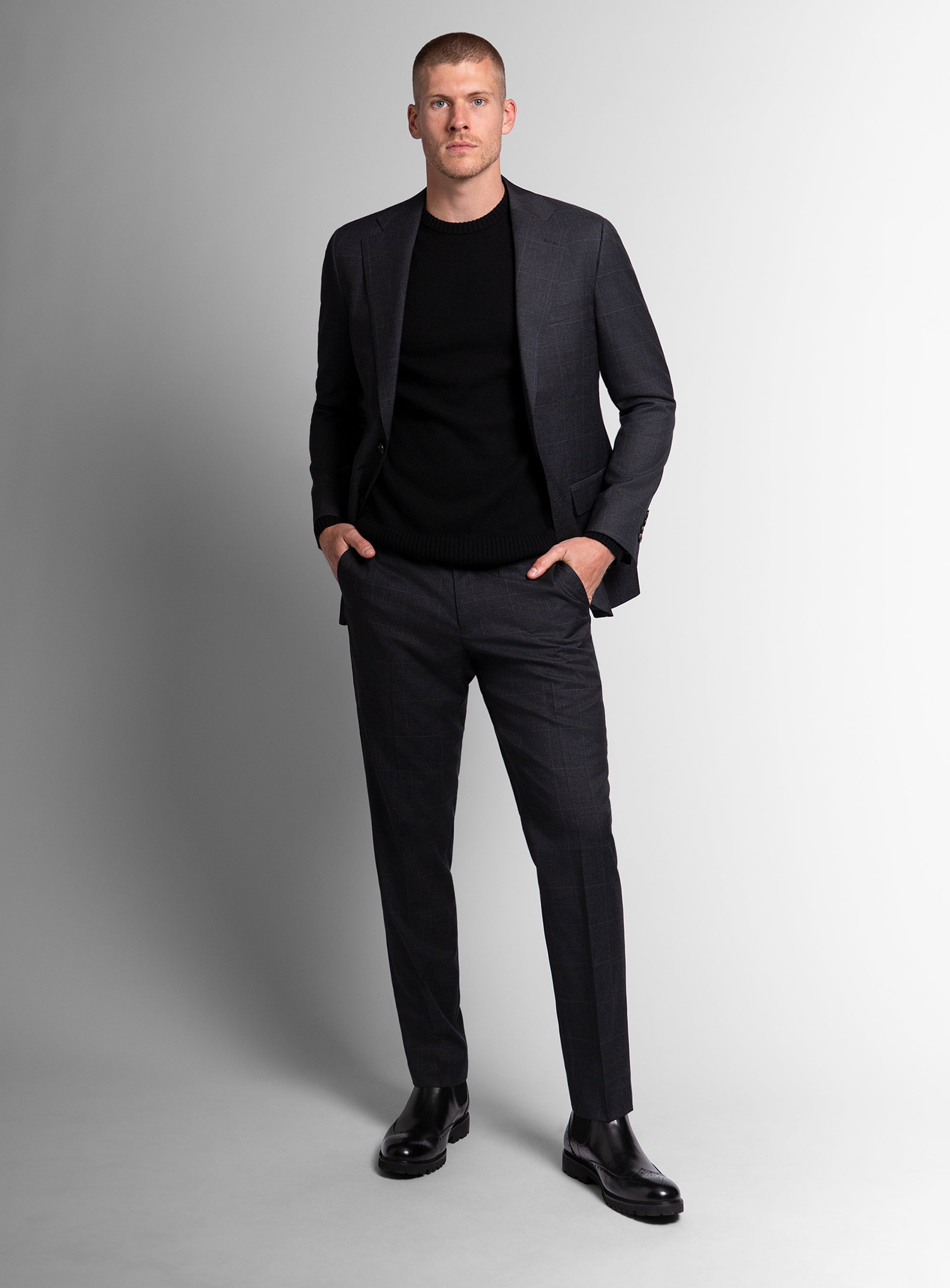 Man wearing charcoal grey suit on a grey background