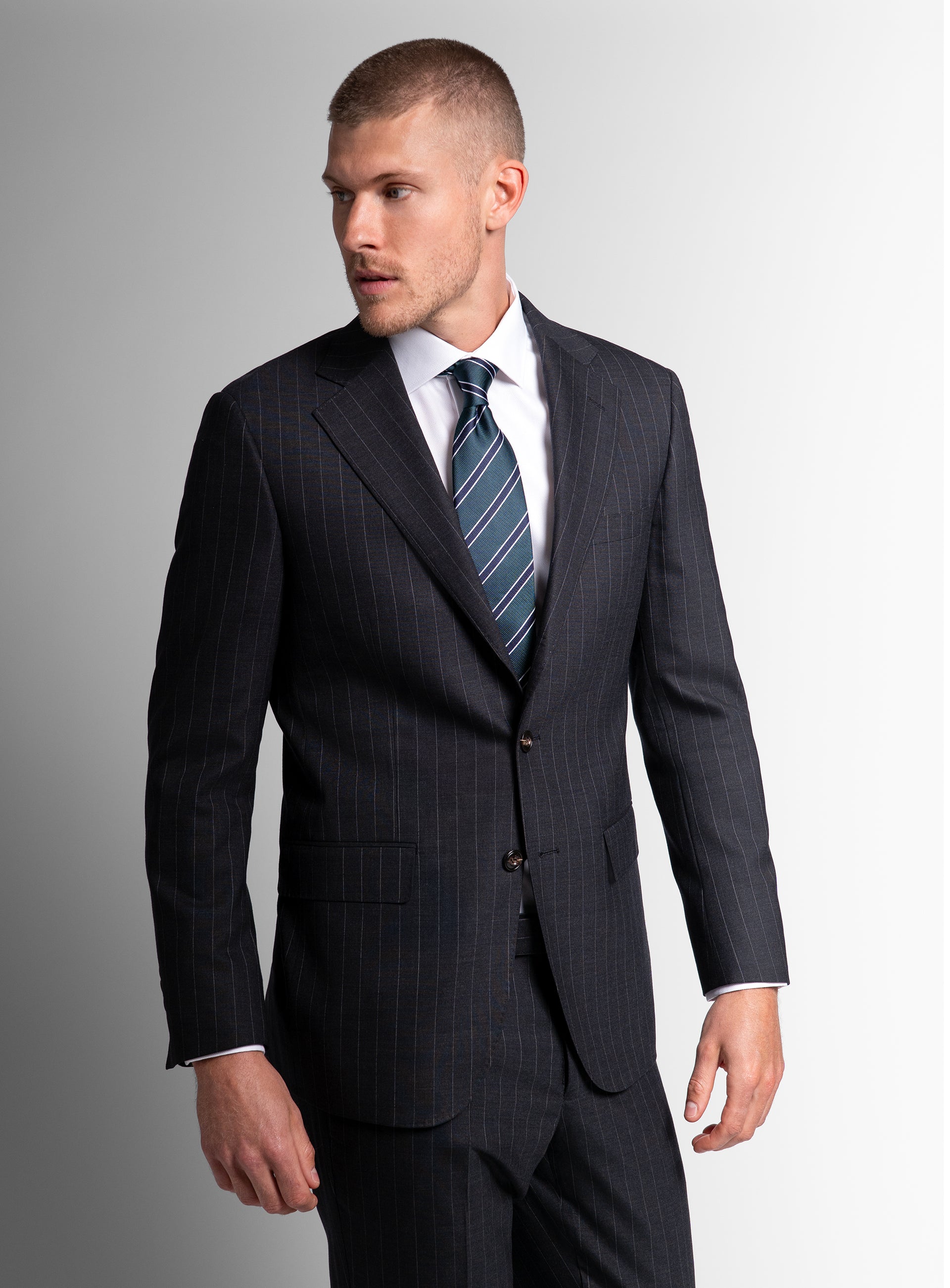 Man looking to his side while wearing the Petruccio Charcoal Pinstripe Suit