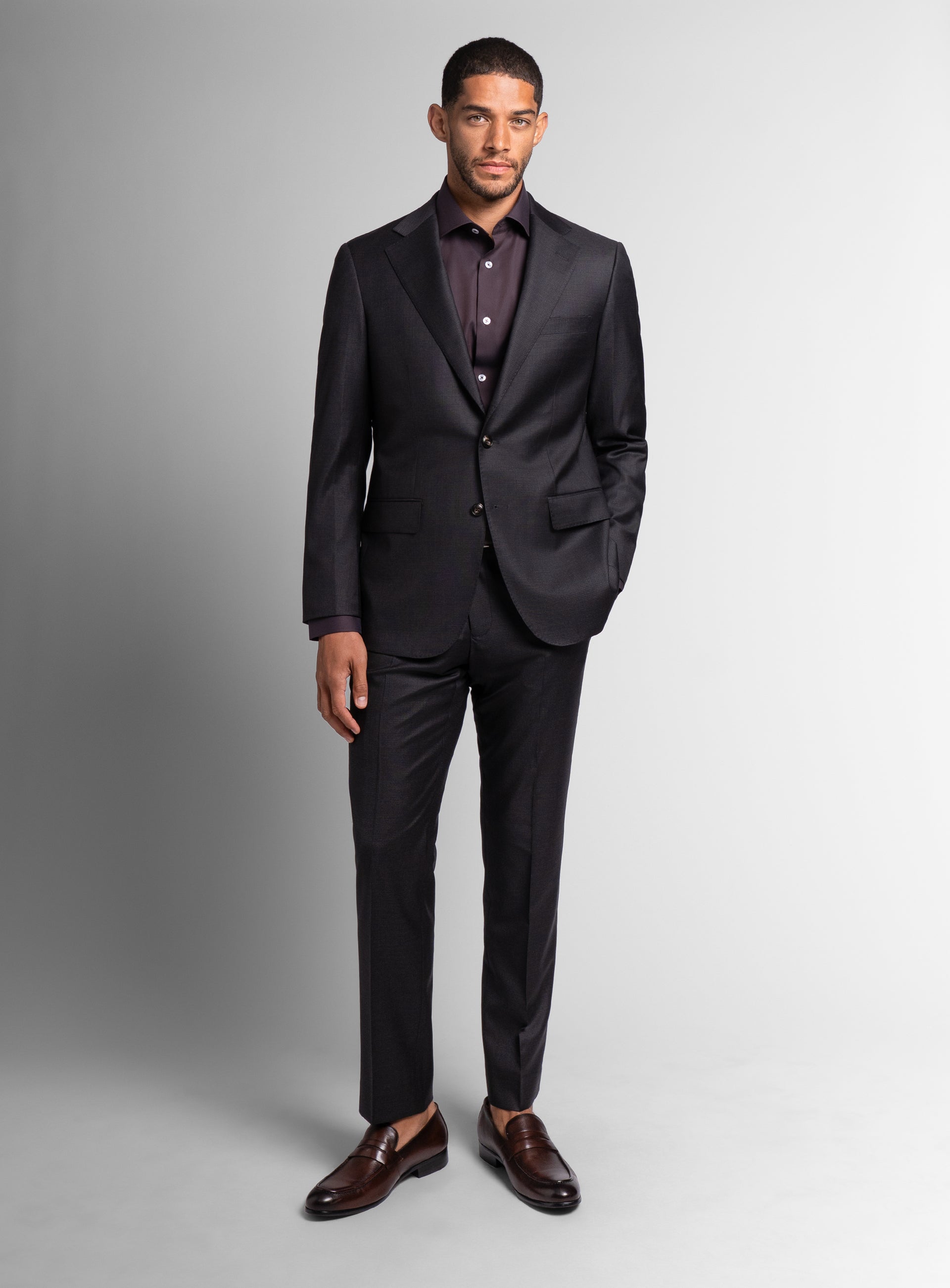Man standing with his hand in the pocket of the the Auditore Charcoal and Brown Suit