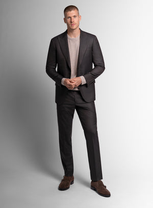 Man wearing a brown suit with a light gray shirt on a white background