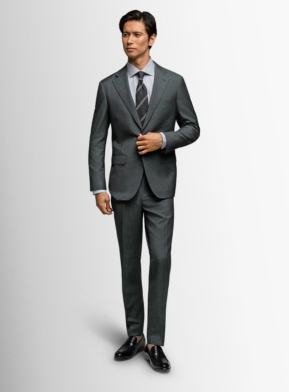 Man wearing a gray suit with a white shirt and tie on a light gray background